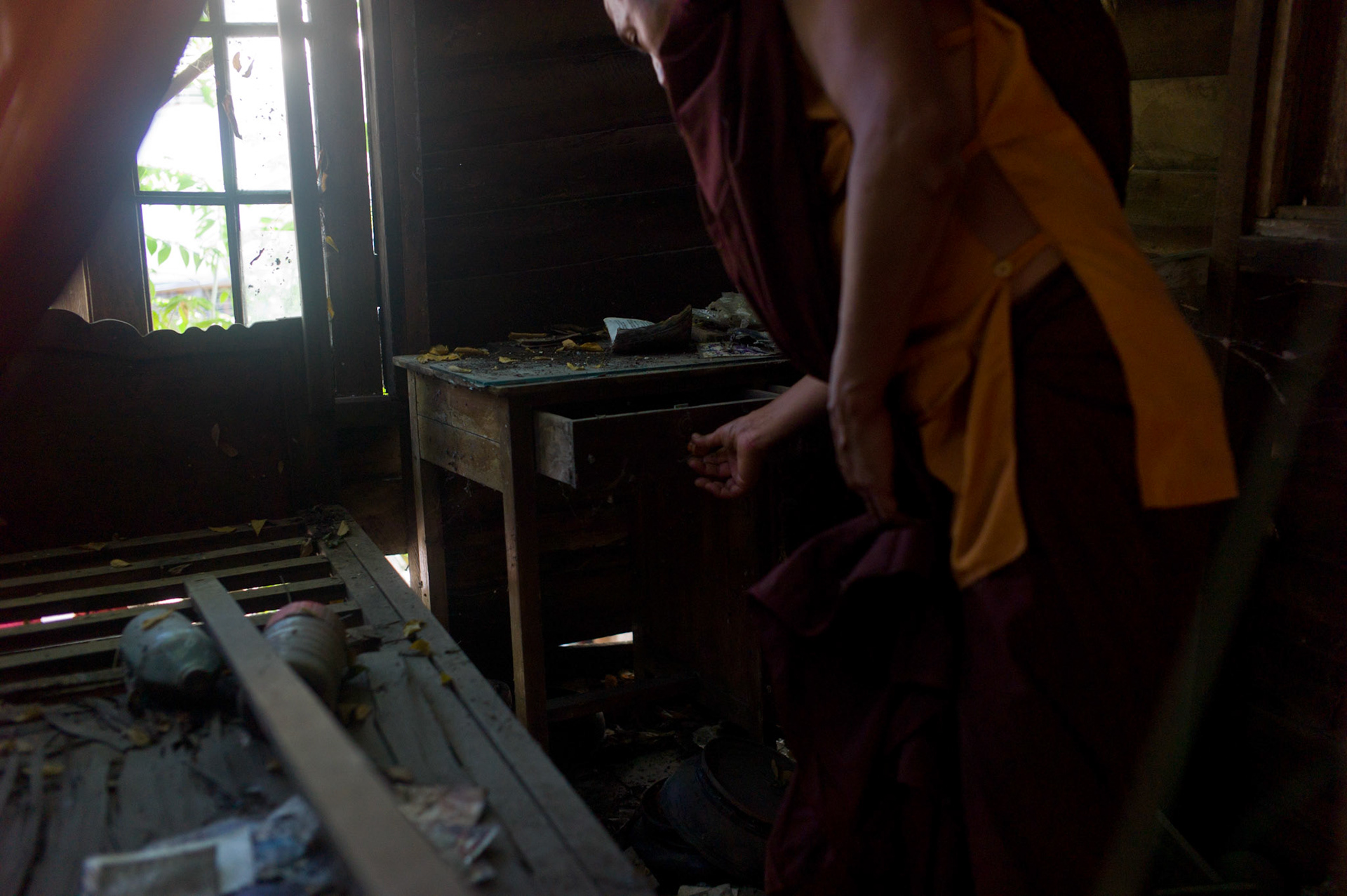 U Eindaka searches his desk to see if any of his personal possessions remain. On September 26th 2007, at the height of Burma's monk led Saffron Revolution, Maggin Monastery in Rangoon, was raided as the regime commenced its brutal crackdown on the protests. On 13th January 2012 the monks were released from prison and more than four years since the monastery was raided and locked, they returned and opened the doors once more. Everything they found was exactly as it was left the night the military regime arrested them and ransacked the buildings.