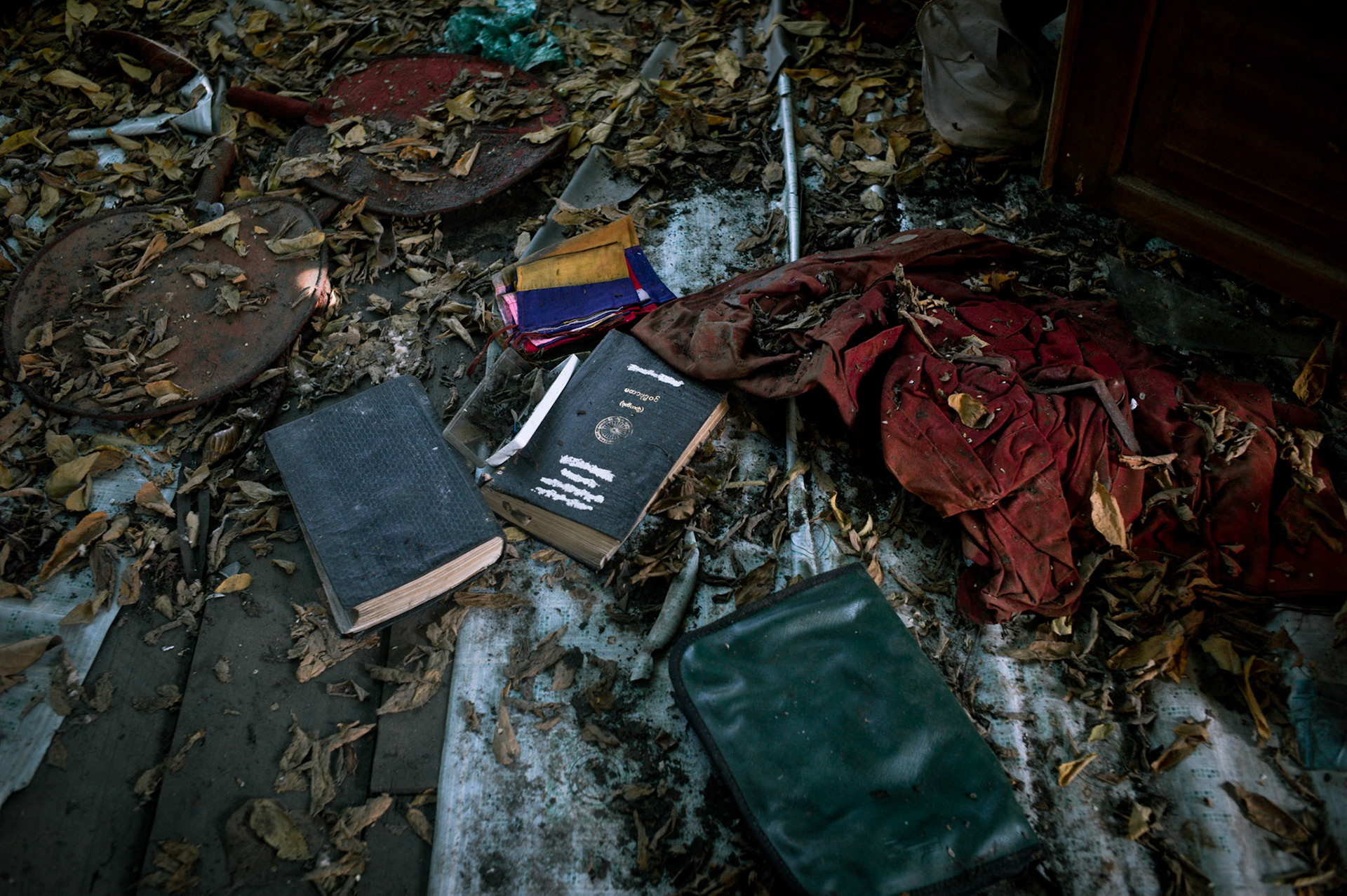 Monks robes torn form their body as they tried to escape lie amongst religious books on the floor. On September 26th 2007, at the height of Burma's monk led Saffron Revolution, Maggin Monastery in Rangoon, was raided as the regime commenced its brutal crackdown on the protests. On 13th January 2012 the monks were released from prison and more than four years since the monastery was raided and locked, they returned and opened the doors once more. Everything they found was exactly as it was left the night the military regime arrested them and ransacked the buildings.