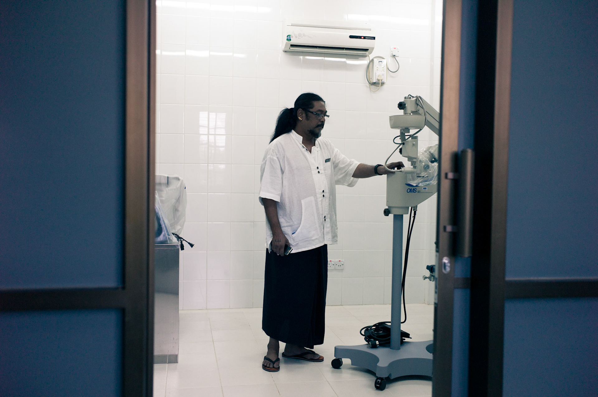 Kyaw Thu stands in the Operating Theatre at the Thukha Free Clinic at the Free Funeral Service Society. Despite providing free medical care, the authorities have refused to allow him to use the operating theatre so the equipment is left standing unused