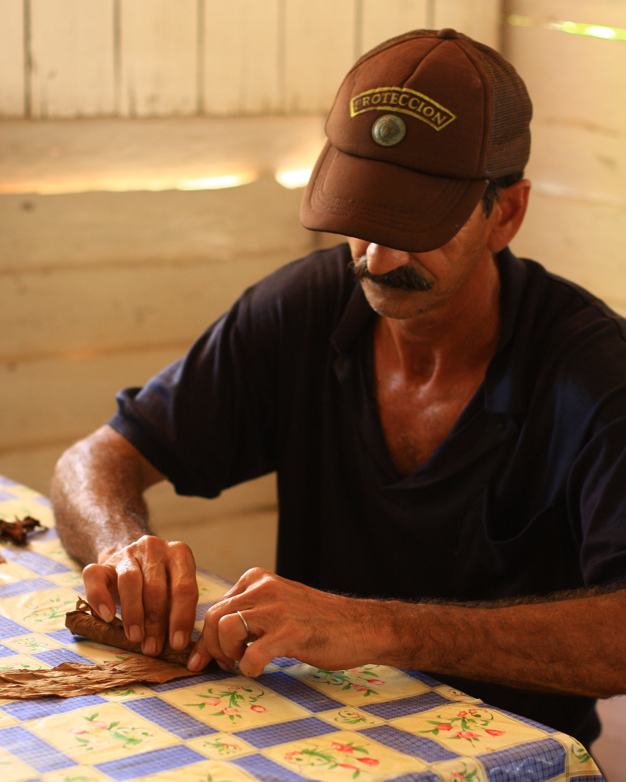 An artisan cigar maker demonstrating his rolling technique.