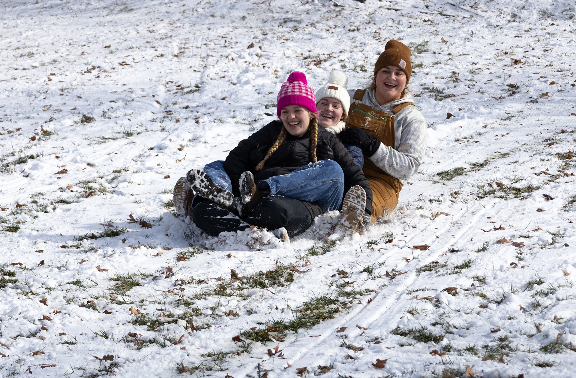 (From left) Rosie Ribble, senior, Mariah Wolff, sophomore, and Madeline Marcus, junior, enjoy the first snow day of the WKU academic year by sledding down Cherry Hall Hill  on Feb. 20, 2025.