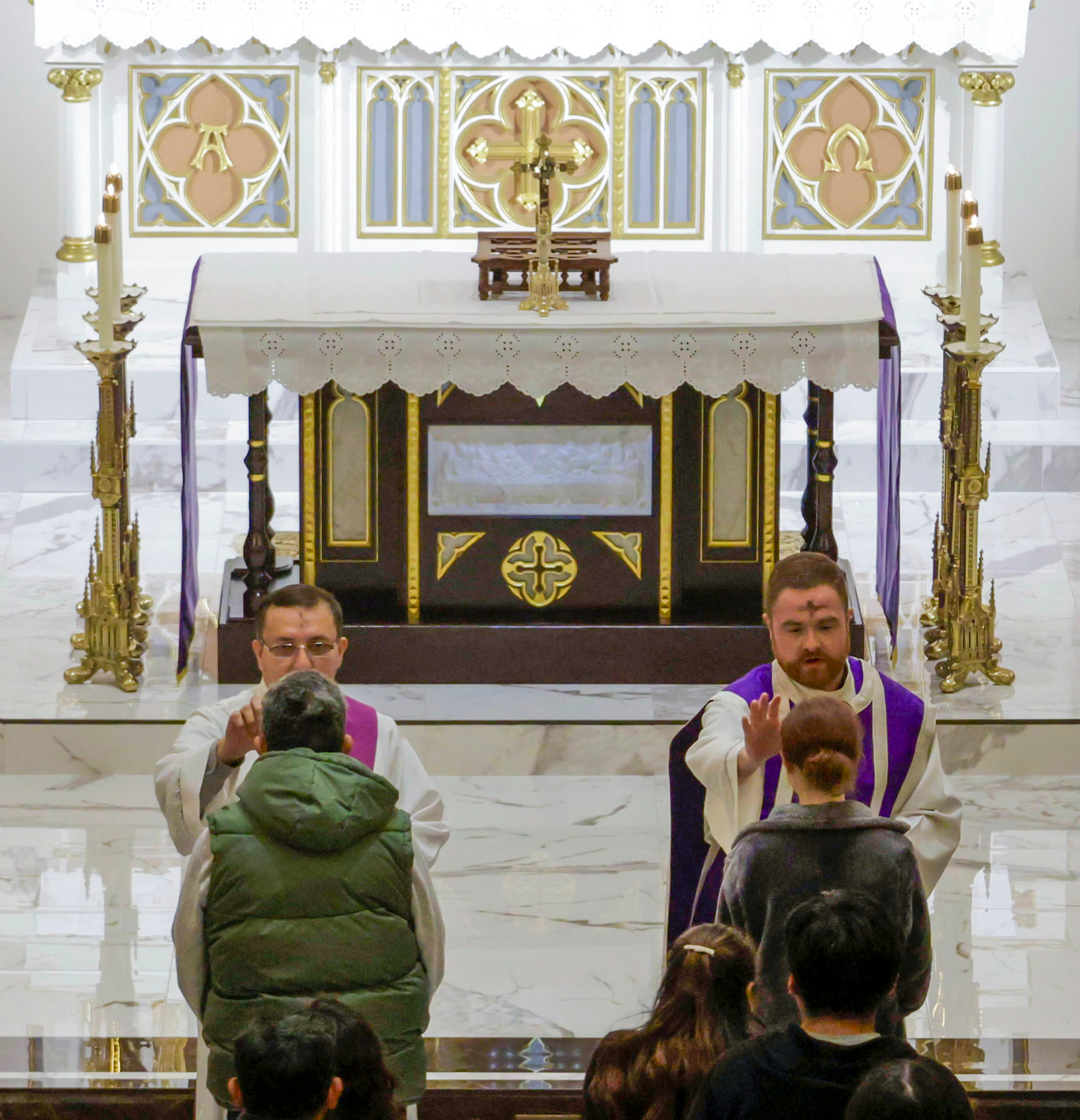 Rev. Corey D. Bruns and Rev. Mr. René Amaya mark the sign of the cross on worshipers foreheads at Ash Wednesday Mass at St. Joseph Catholic Church in Bowling Green, Kentucky on Wednesday, March 5. Ash Wednesday  begins the 40-day Lenten season for Christians. This season is a significant piece of the Christian faith. Lent will conclude on April 17 this year. 