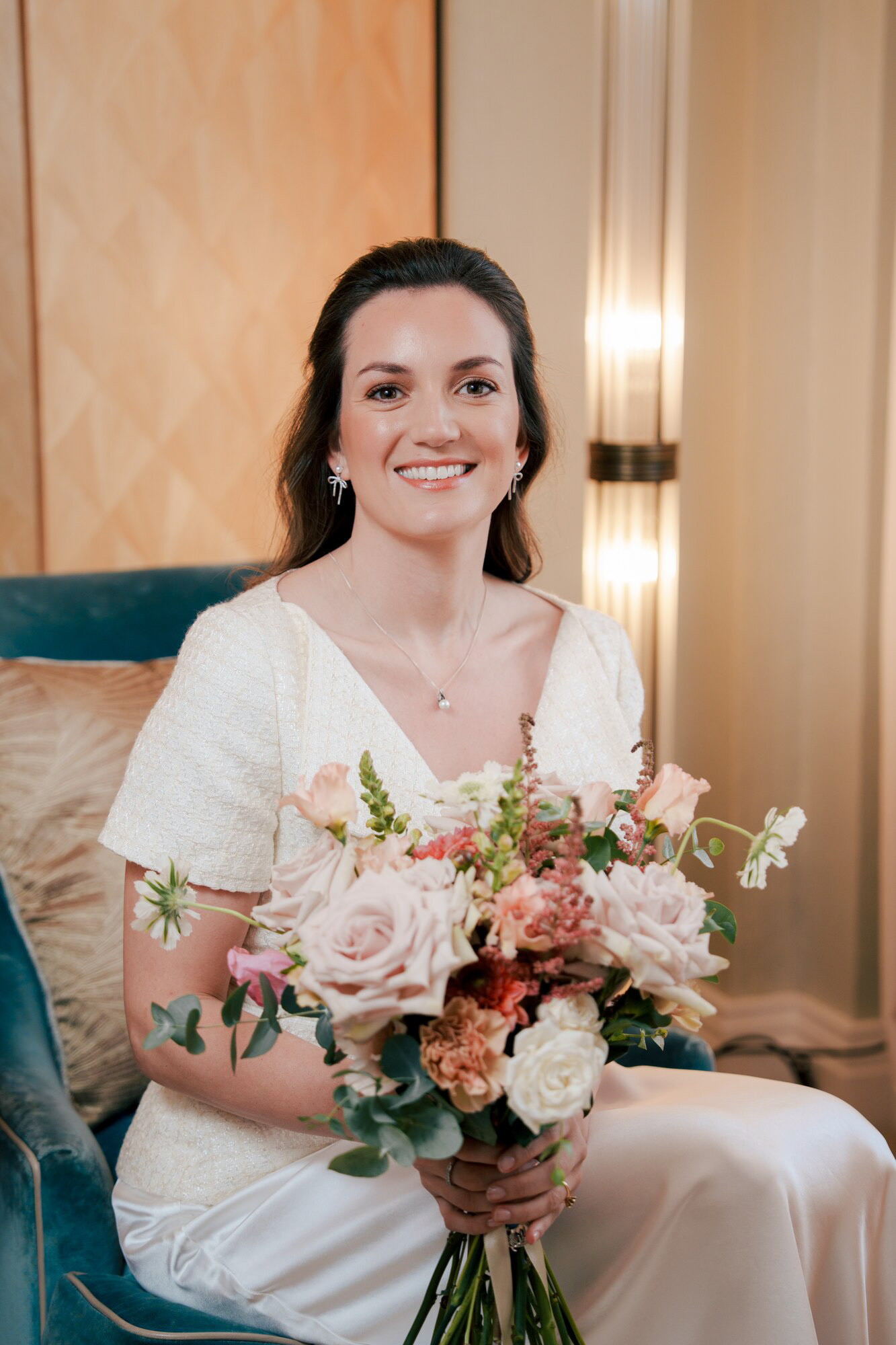 Smiling bride with her wedding bouquet in a Claridge's suite before her Marylebone Town Hall wedding