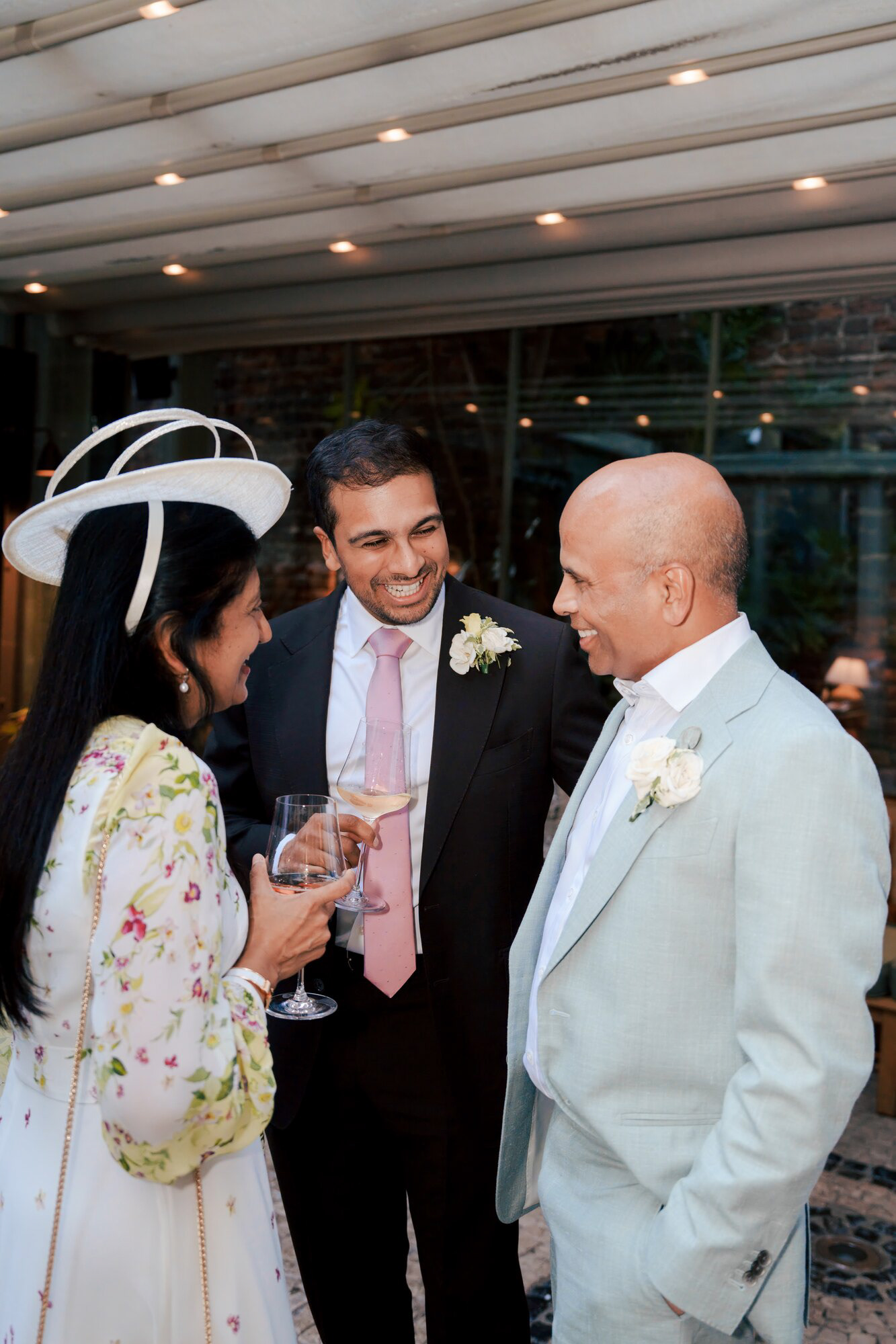 Groom chatting with family over drinks at Luca, Clerkenwell, after the wedding