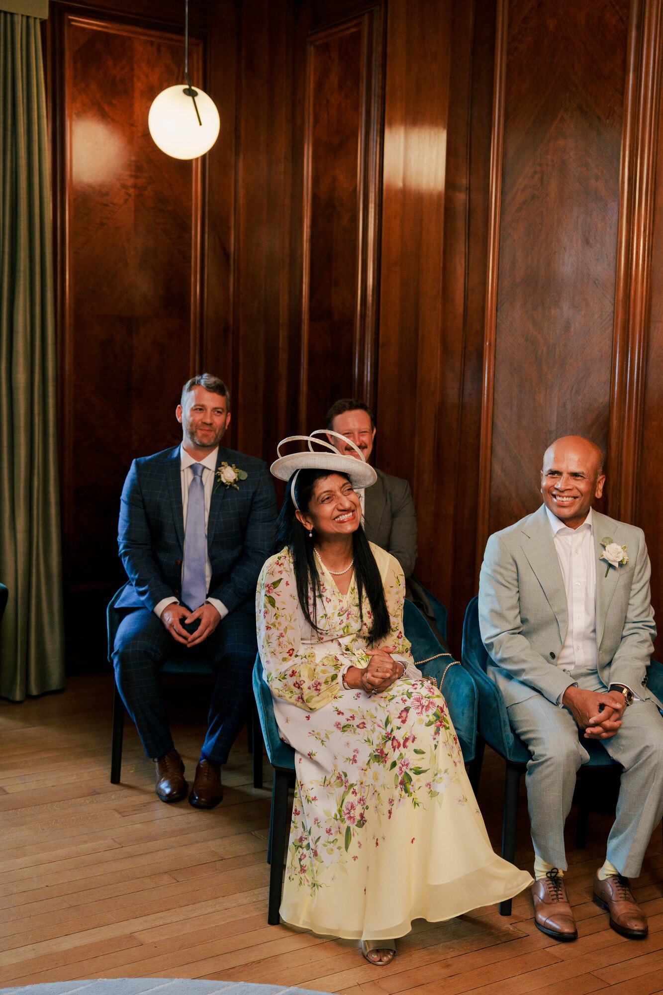 Family smiling during the civil ceremony in the wood-panelled Marylebone Room