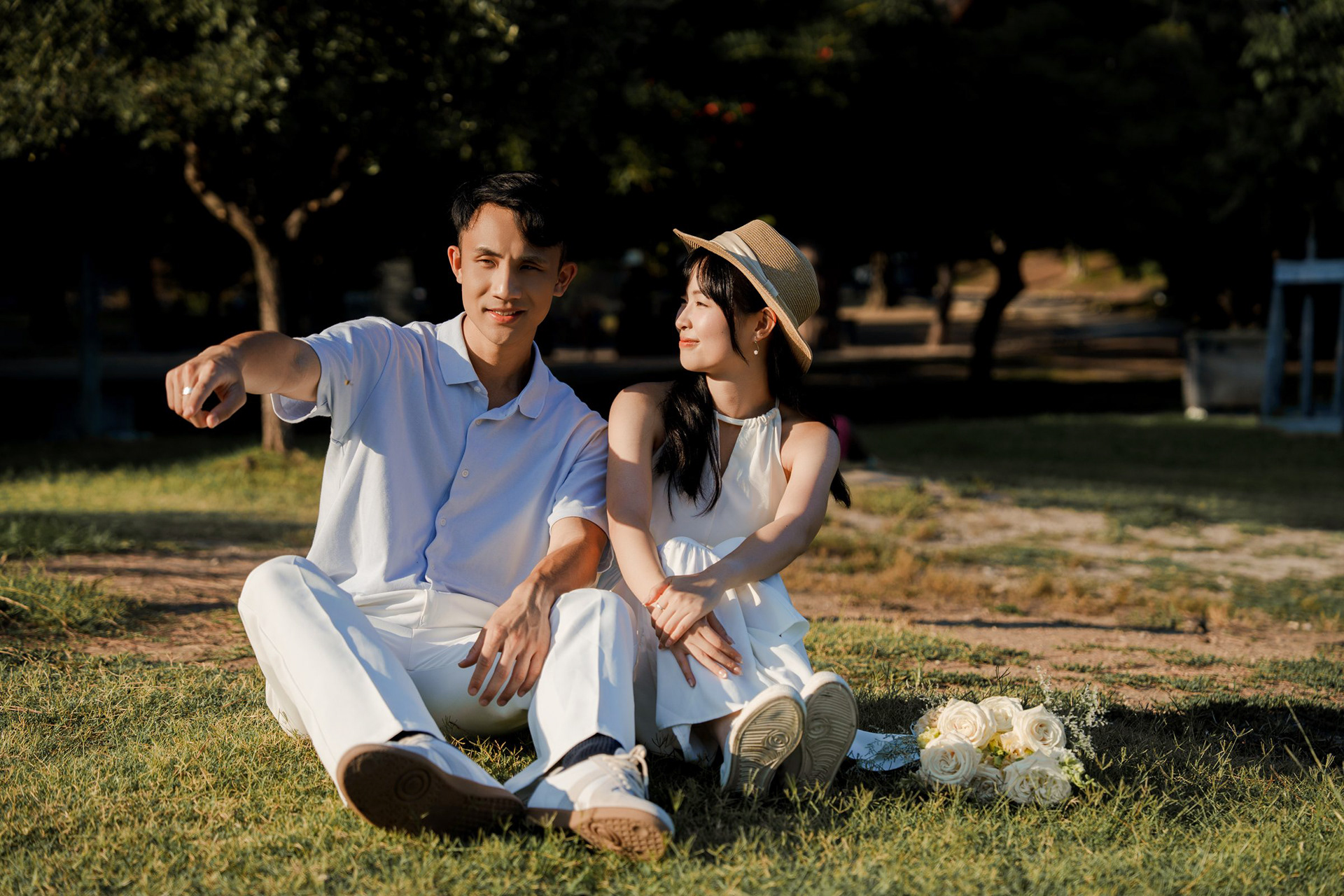 Sitting on the grass on Castle Hill, the groom pointing across the park