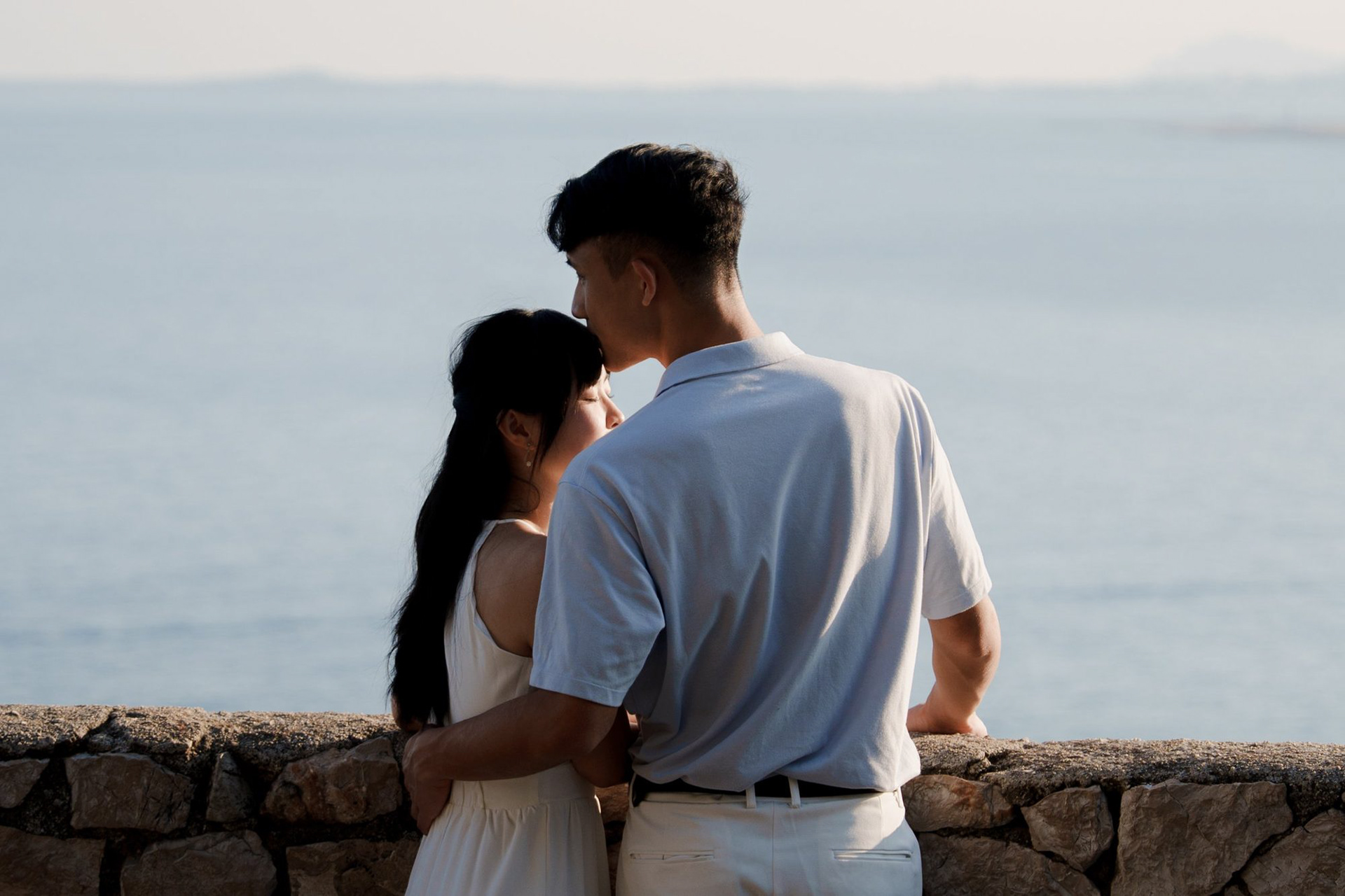Forehead kiss at the Castle Hill viewpoint in Nice, looking out over the Mediterranean at sunset