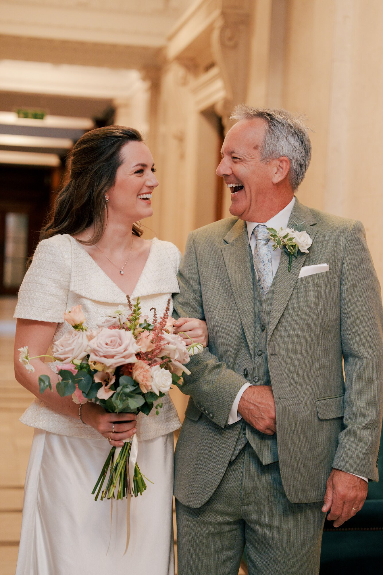 Bride laughing with a family member before walking into her ceremony at Marylebone Town Hall