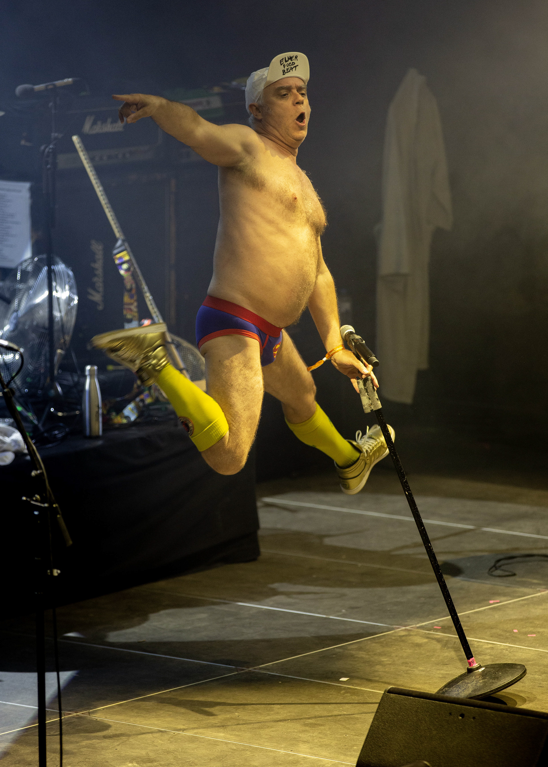 Artiste en performance au festival Rolling Saône, sautant sur scène vêtu d'une tenue colorée et humoristique.