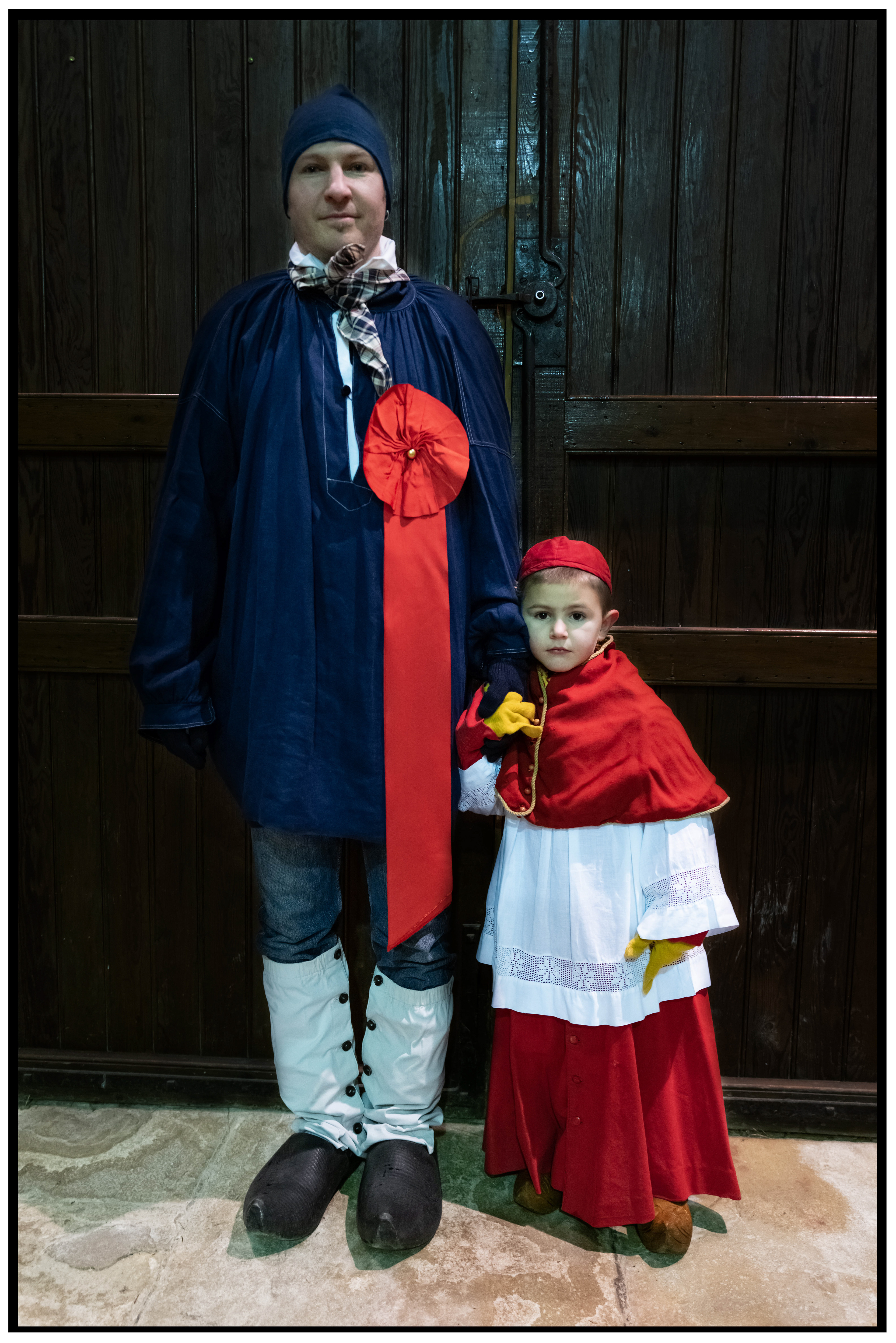Homme en costume traditionnel de paysan avec son enfant, célébrant la Saint-Vincent.