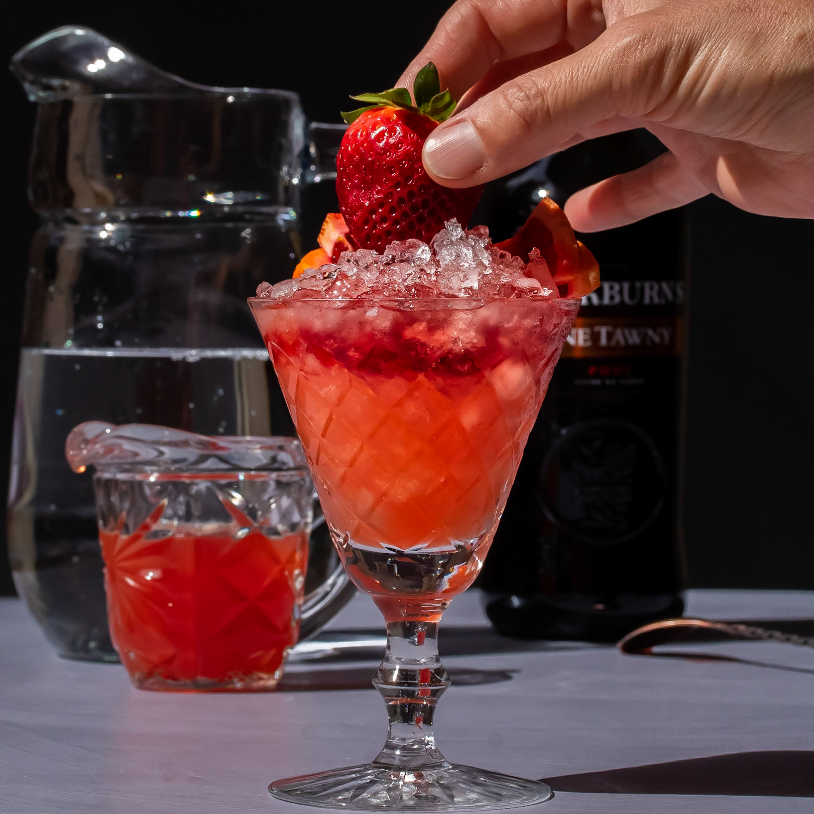garnishing improved strawberry shrub, featured in highlights by @advancedmixology