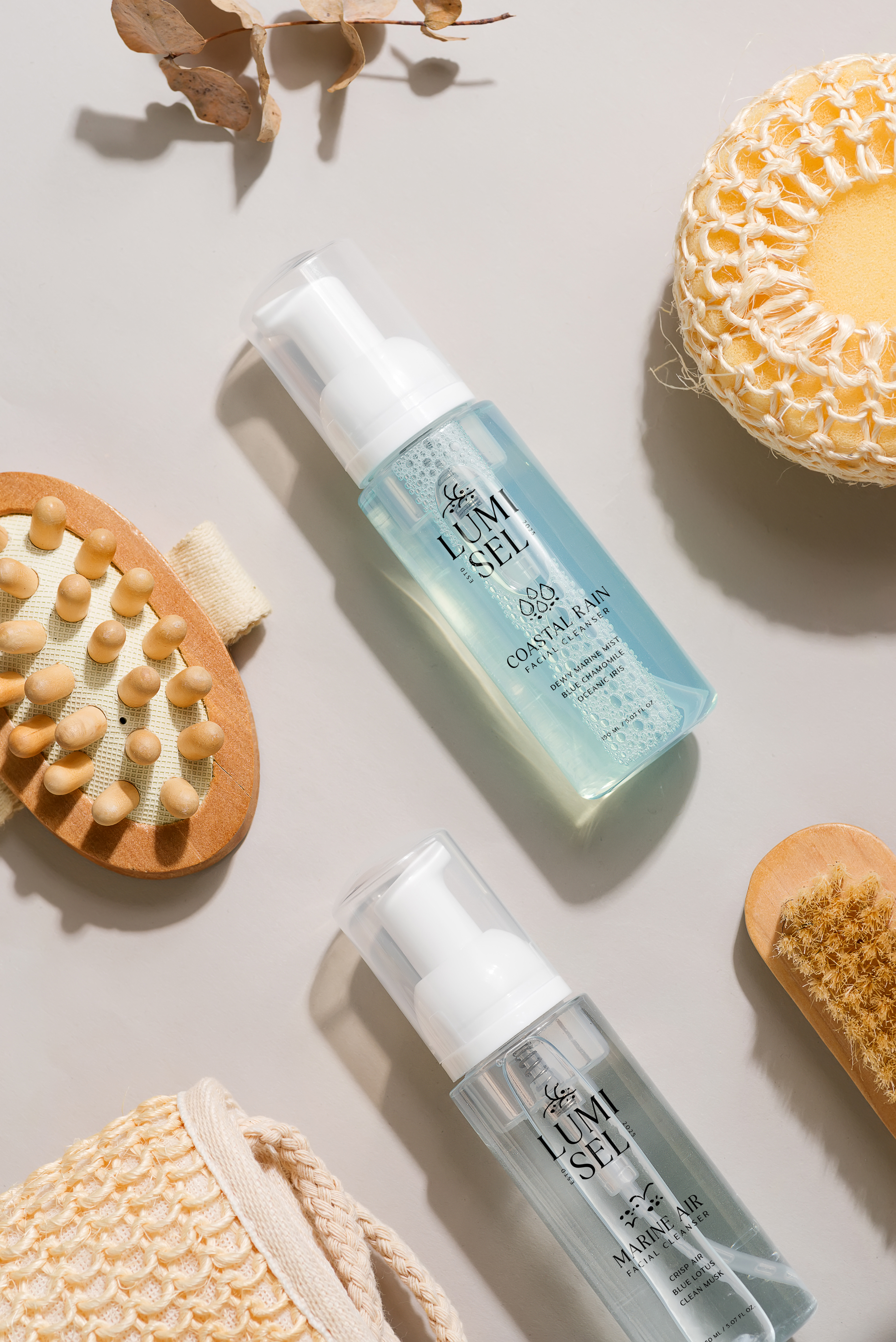 Facial Cleansers on a background need to body scrubs and sponges. CLensars include Coastal Rain and Marine Air