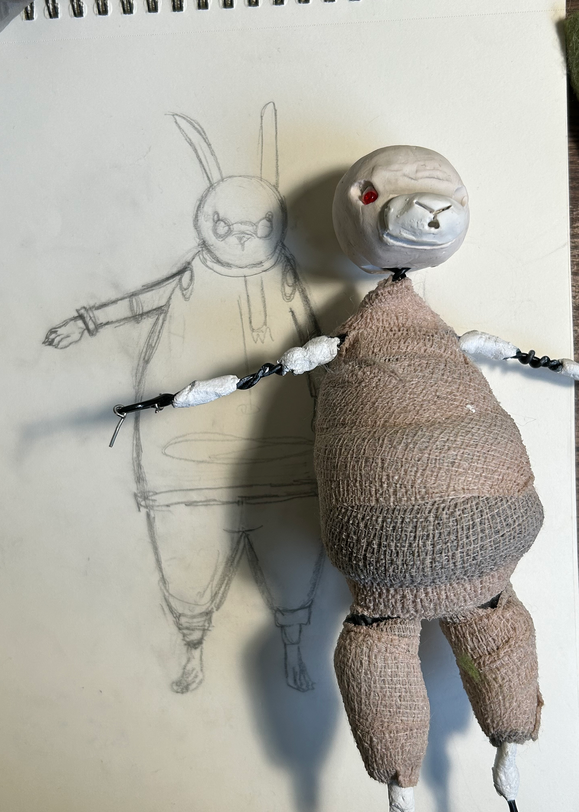 using a sketch to compare proportions, I made a character from armature wire, epoxy putty, polymer clay, old acoustic foam and bandages