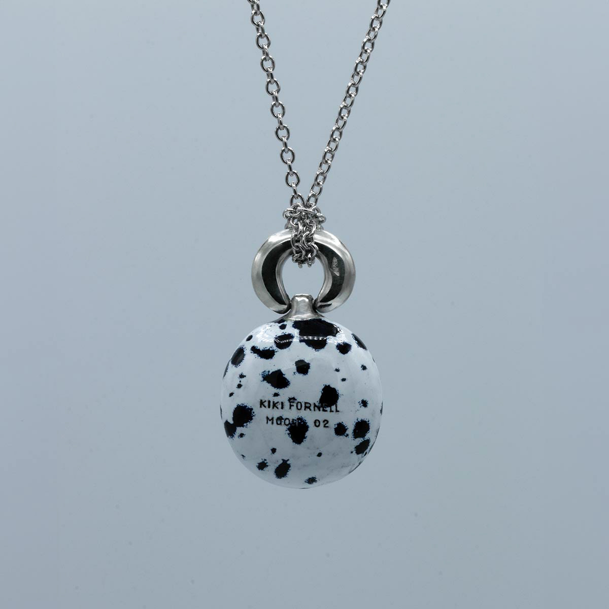 Back side of the pendant with the individual number. Face arrière du pendentif avec le numéro individuel.