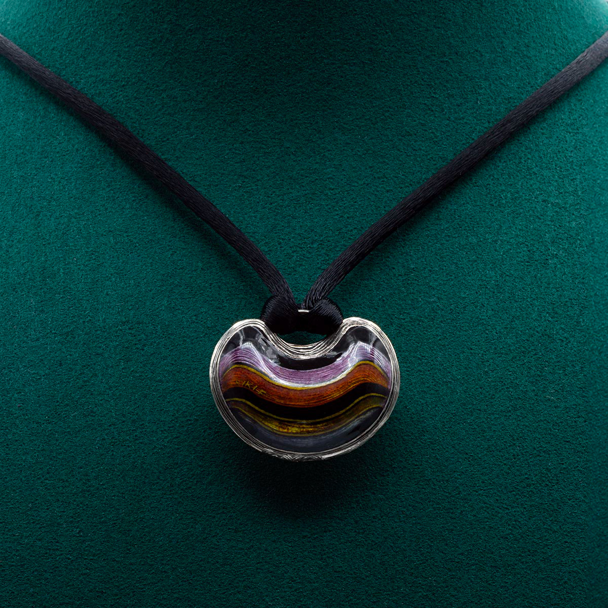 LES PENDELOQUES P002 Necklace Stripes in silver, featuring a hand-engraved and enamelled pendant with a violet, pink, yellow, and black striped pattern. Crafted in champlevé enamel technique, complemented by a black silk collier with a silver 925/1000 lock and a 1.5 mm cubic zirconia. Limited edition handmade jewelry by Kiki Fornell.