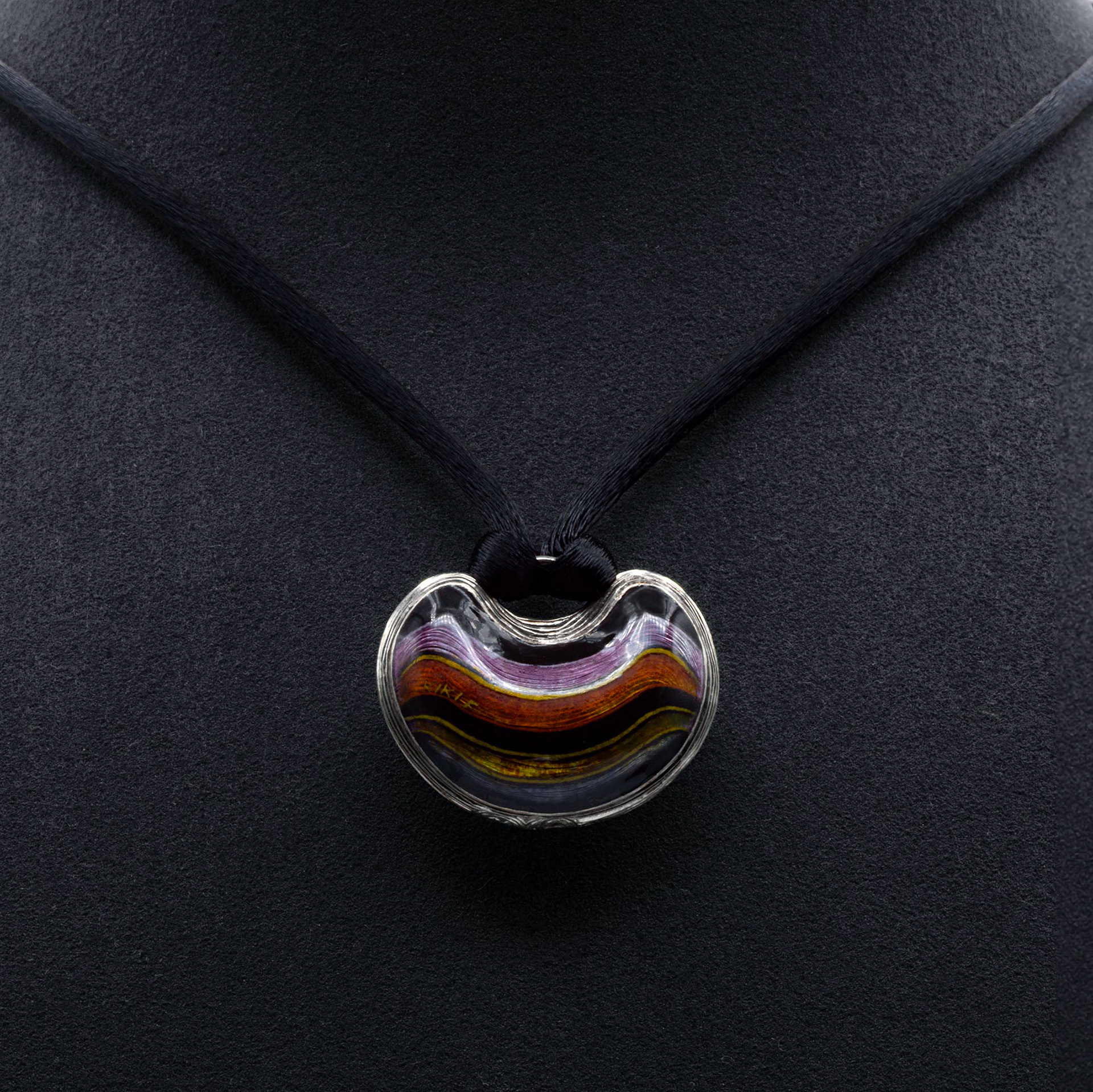 LES PENDELOQUES P002 Necklace Stripes in silver, featuring a hand-engraved and enamelled pendant with a violet, pink, yellow, and black striped pattern. Crafted in champlevé enamel technique, complemented by a black silk collier with a silver 925/1000 lock and a 1.5 mm cubic zirconia. Limited edition handmade jewelry by Kiki Fornell.
