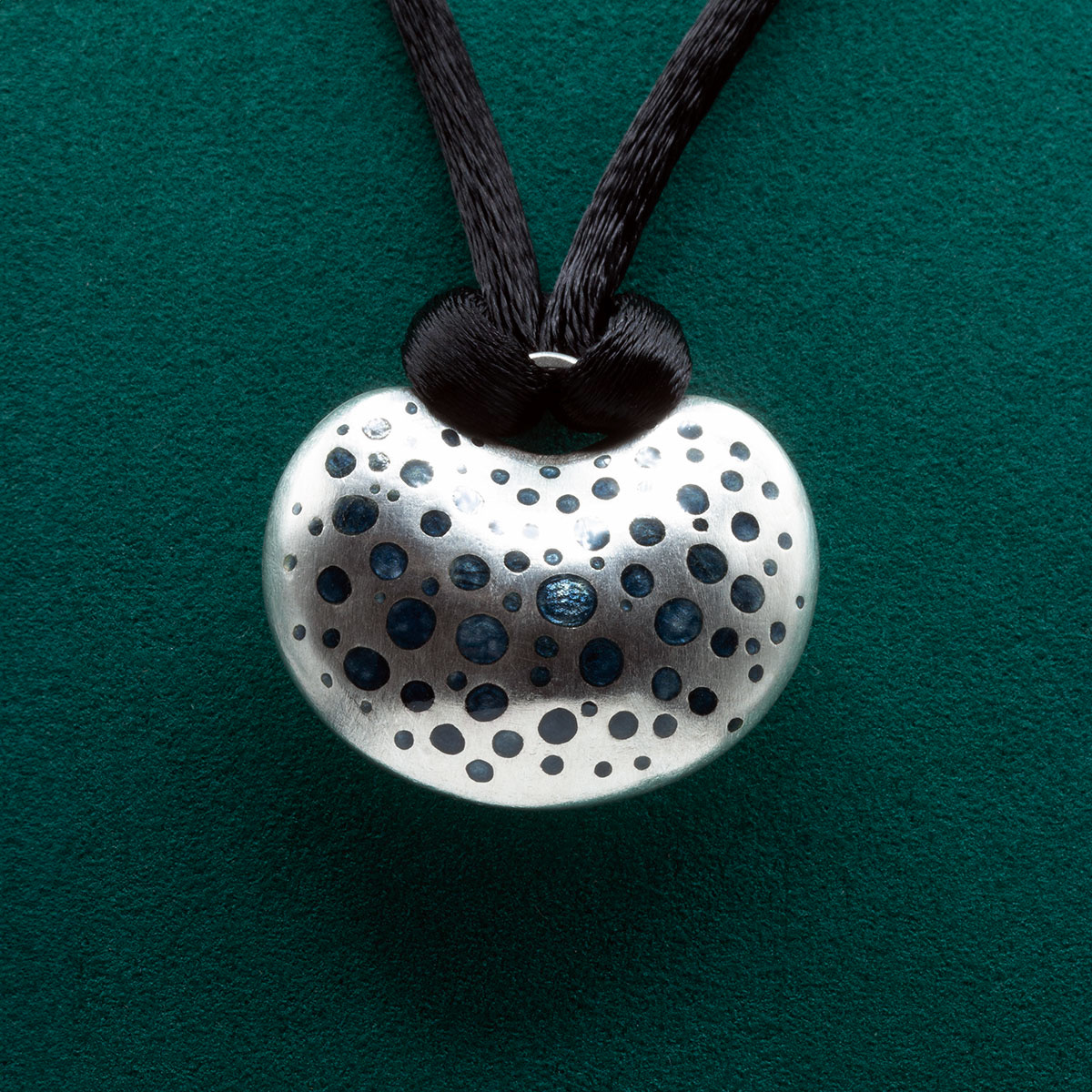 Handmade silver pendant with champlevé enamel and diamond, featuring a polka dot pattern inspired by sea creatures. Complemented by a black silk collier with a silver clasp. Designed and crafted by Kiki Fornell.
