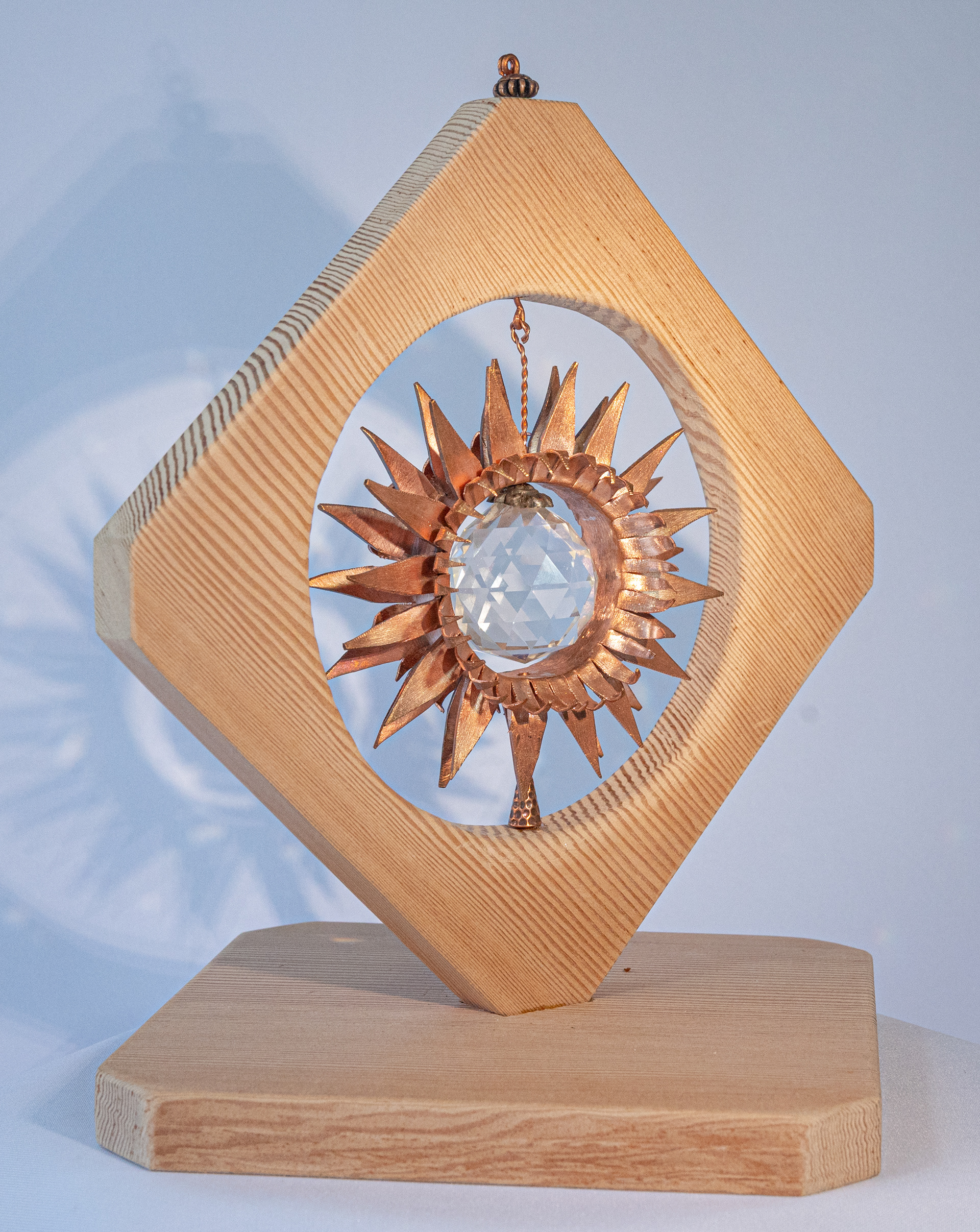 "Sunflower" (profile view) is a copper flower with large crystal centre on a handmade fir base,  10.5 inches high x 7.5 inches wide x 7.5 inches deep, $175