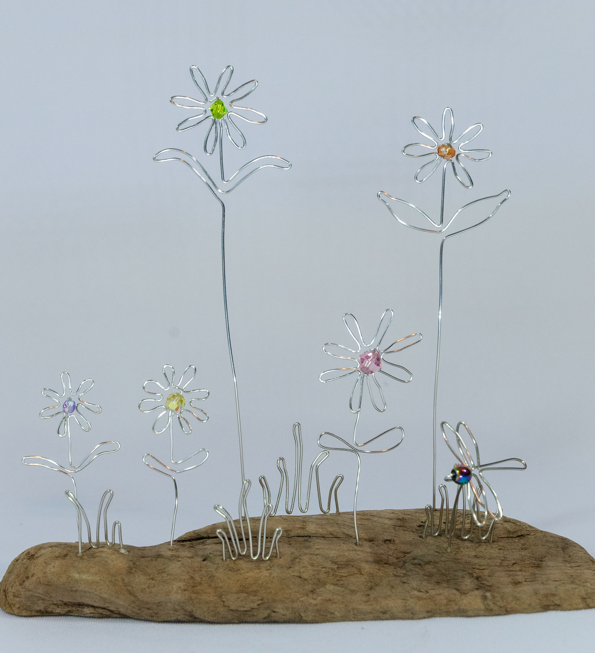 "Spring Flowers" are made of hand shaped aluminum wire with glass crystal centres on a driftwood base, 8 inches wide x 2.5 inches deep x 7 inches high, $75
