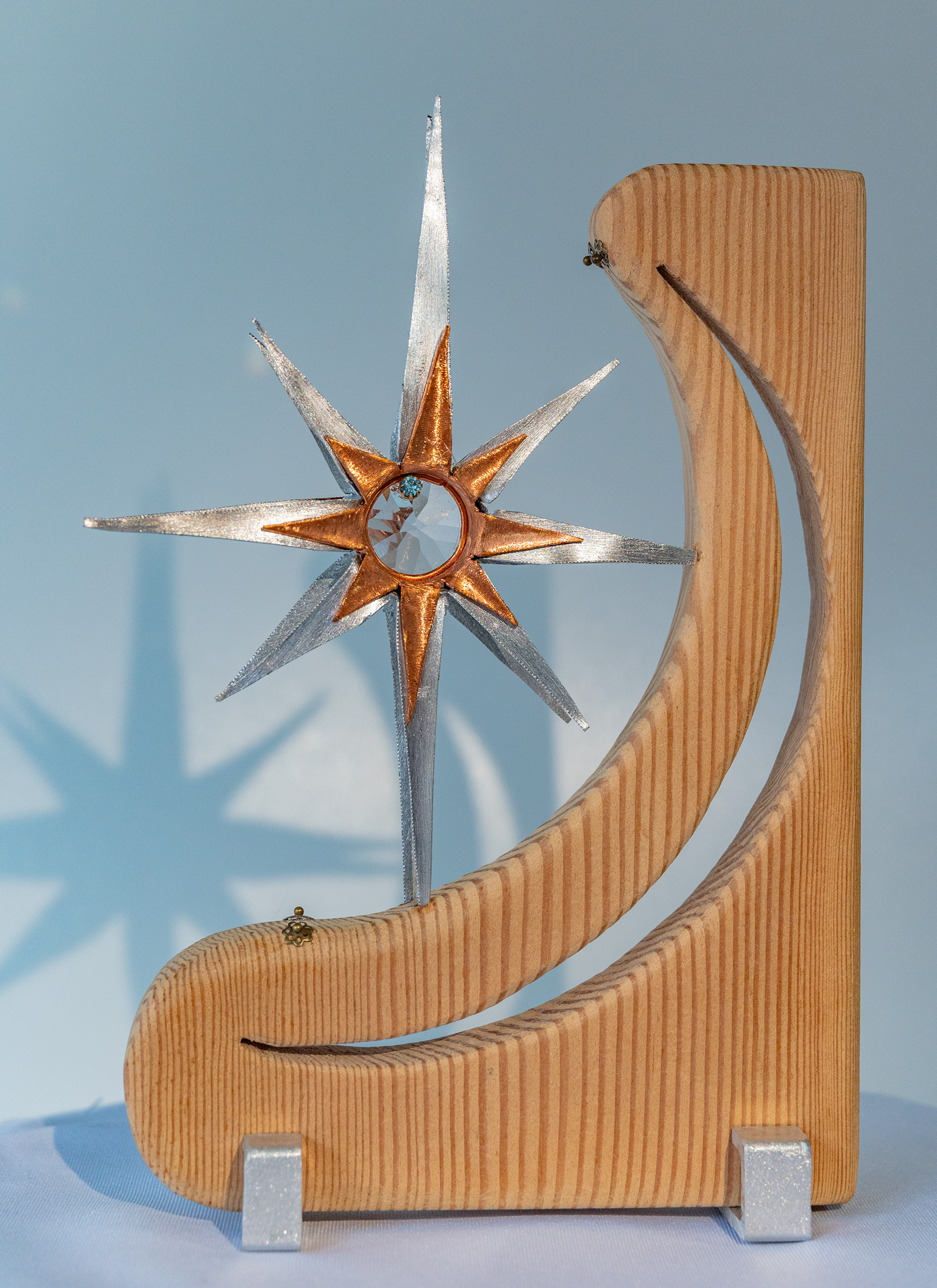 "Starry Moon" is a copper and aluminum star with a clear crystal centre set in fir with a cutout crescent moon and aluminum feet. 5.5 wide x 8 high x  1.5 deep, $125
