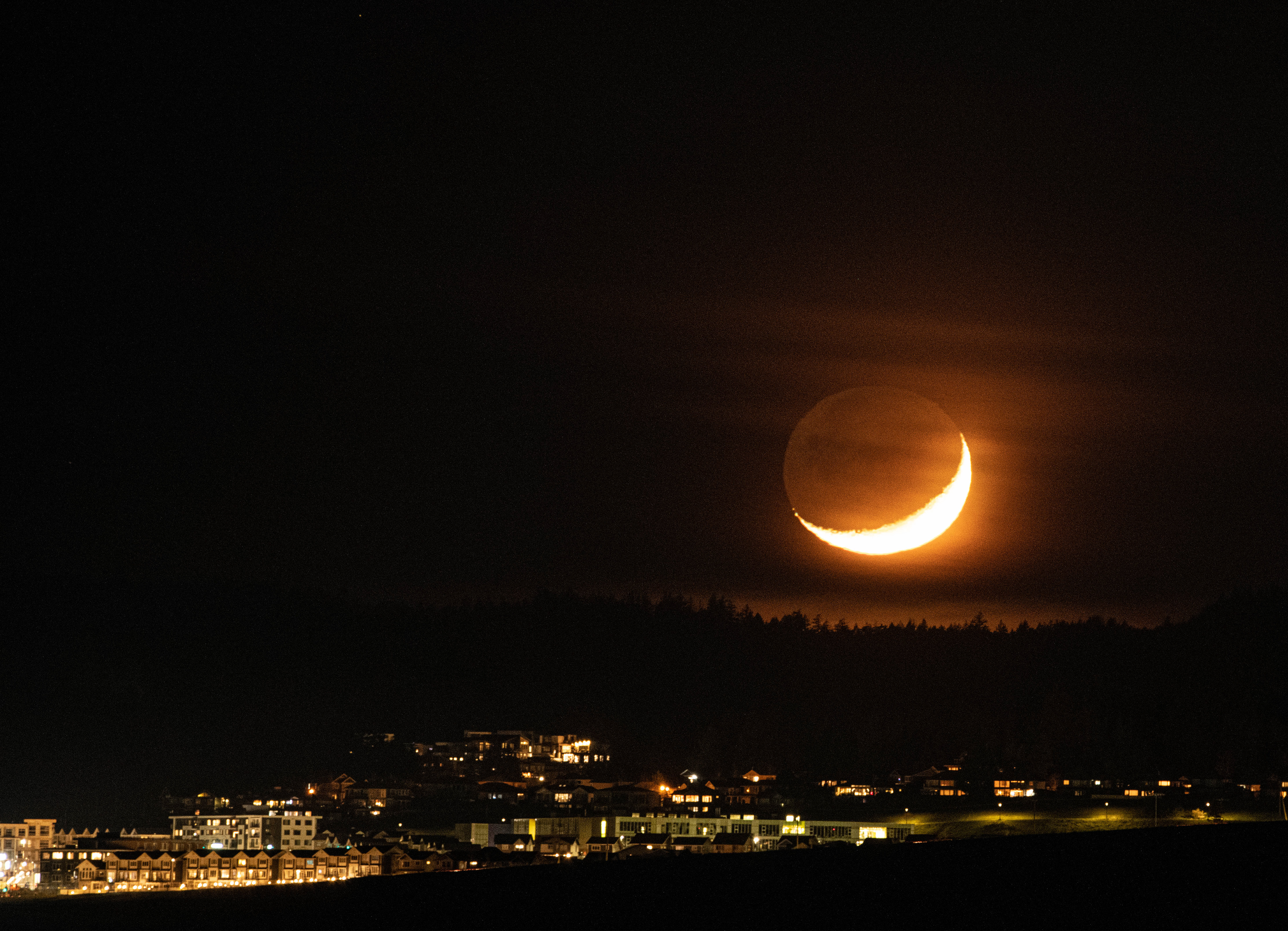 Cresecent moon setting with visible Earthshine over Triangle Mountain in Victoria.