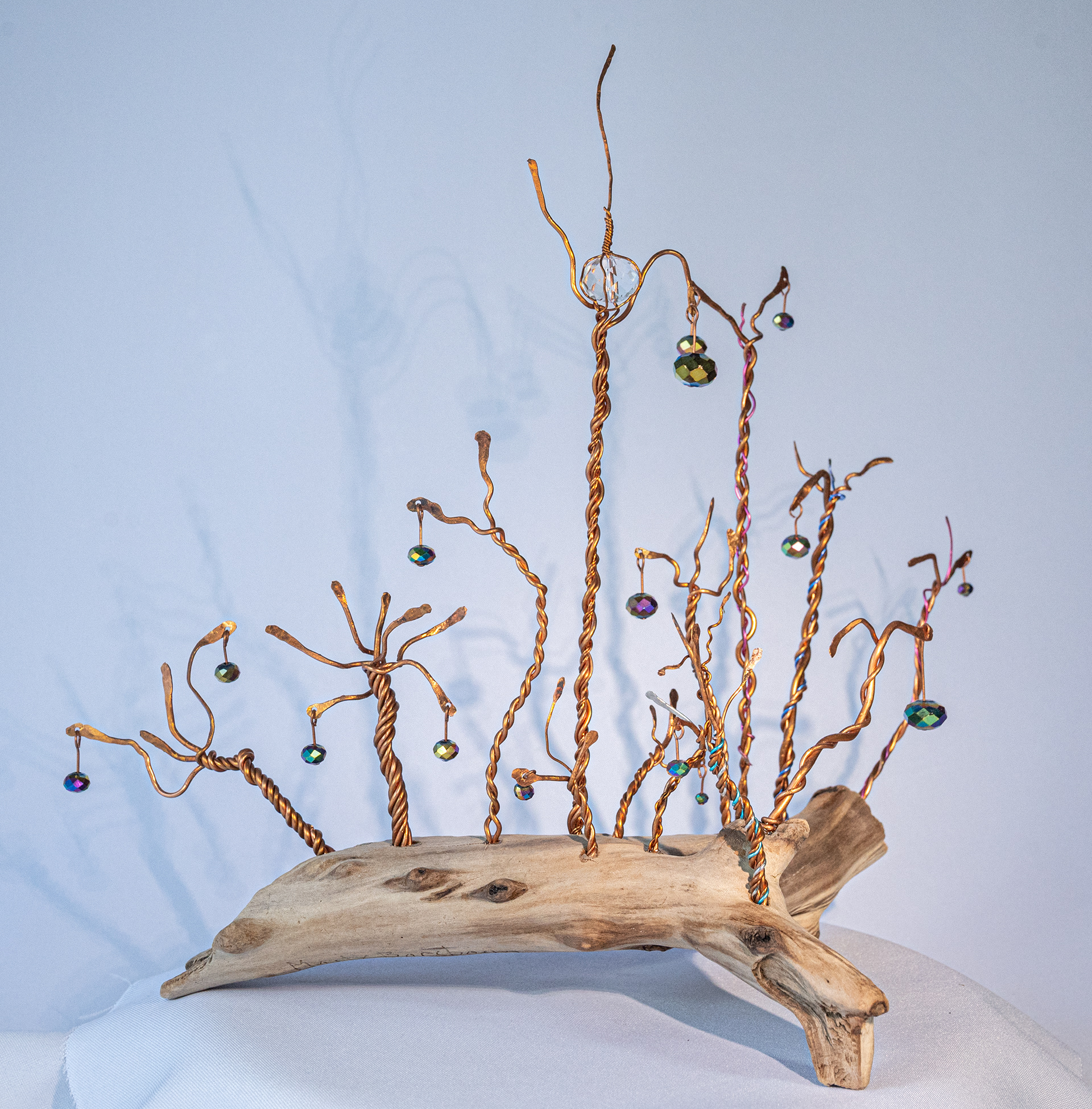 "Enchanted Forest" is a collection of hand twisted copper on driftwood with clear and  iridescent crystals, 11 inches high x 12 inches wide x 8 inches deep, $75