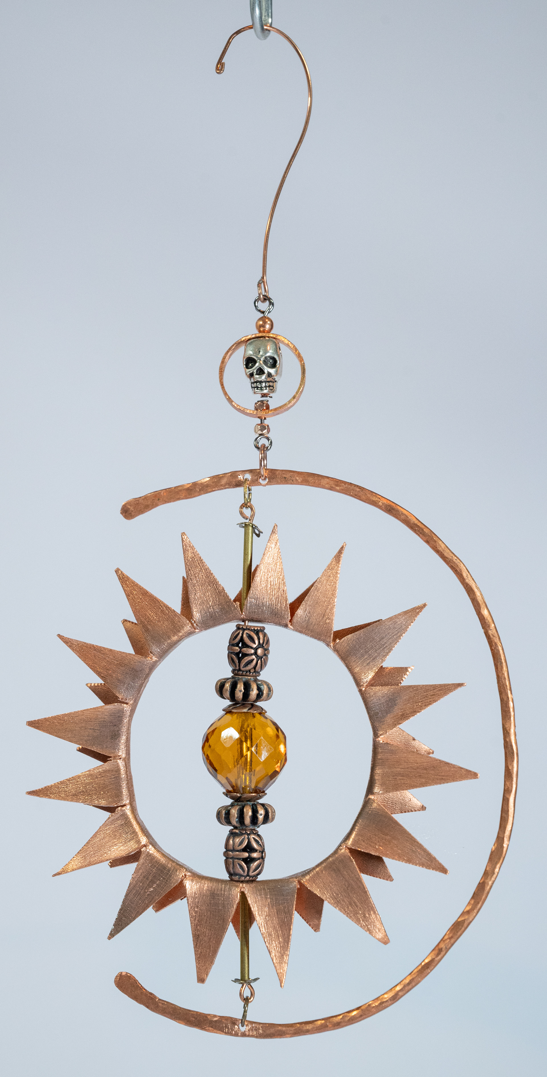 "Crescent Sun", copper with metal findings and amber crystal, 4 inches in diameter, $75
