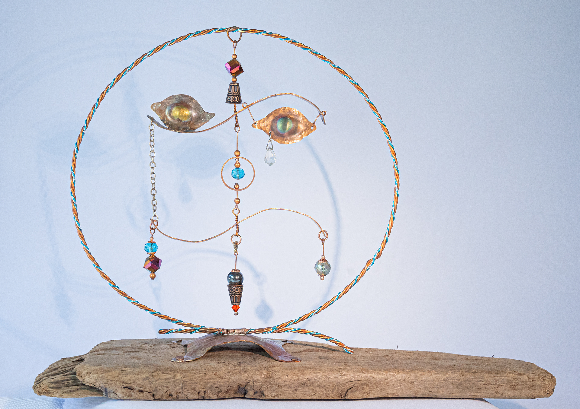 "Funny Face" is made of copper with coloured crystals, hand twisted wire with copper base attached to driftwood,  13.5 inches wide x 10 inches high x 5 inches deep, $125