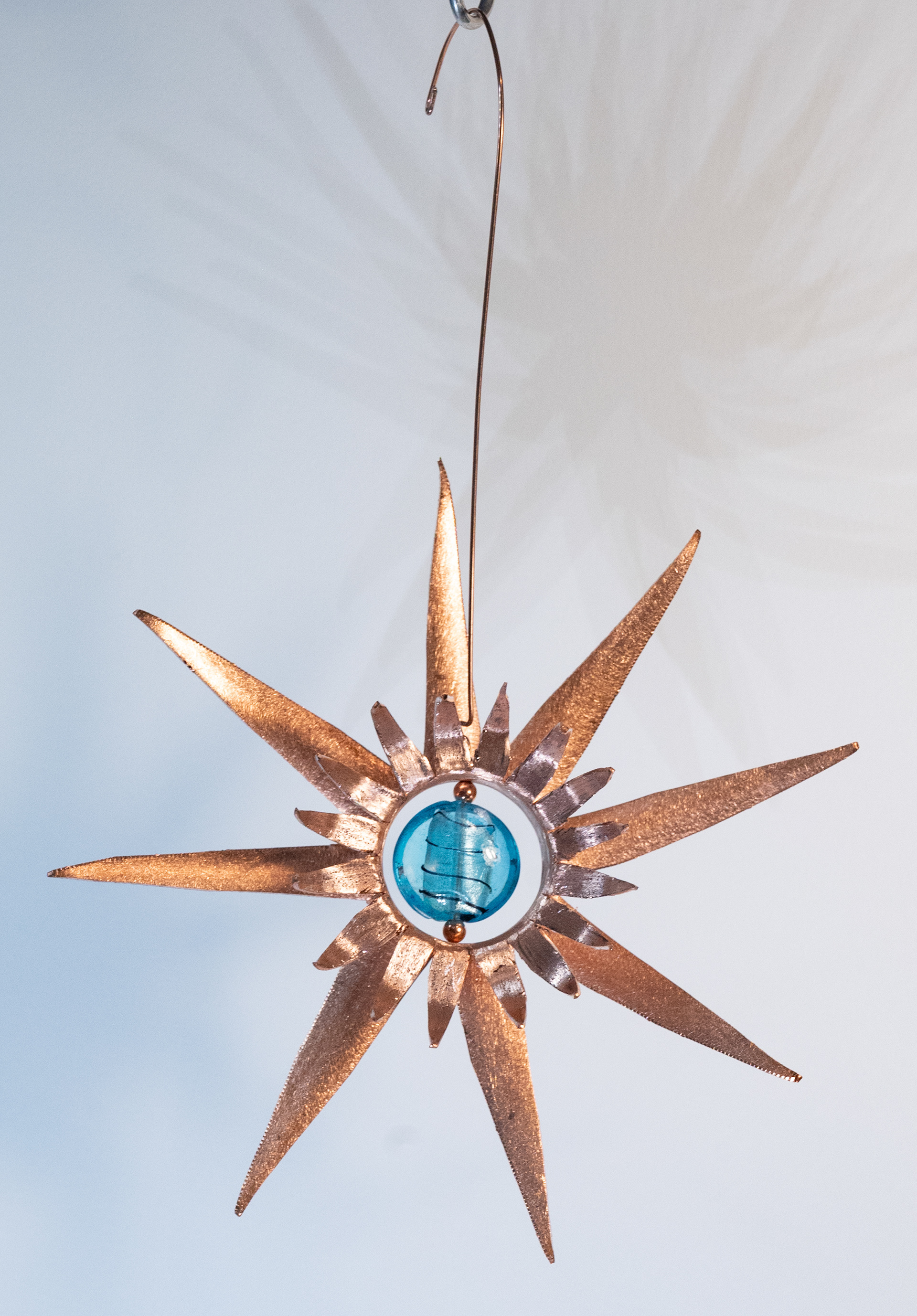 "Blue Burst" is a handcut copper sun with a turquoise coloured glass centre, $75