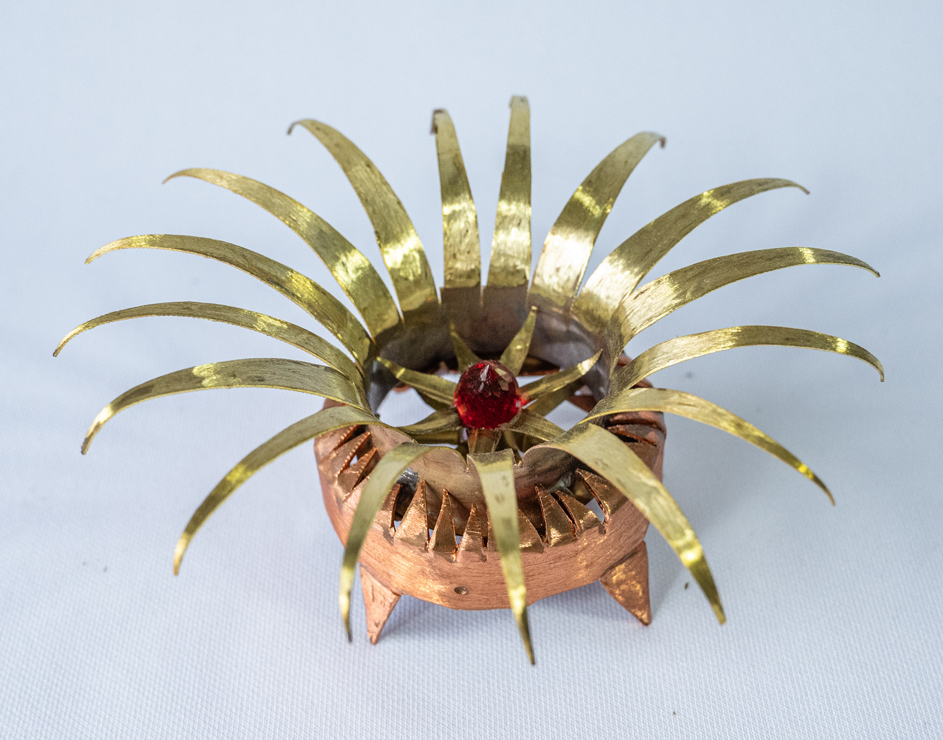 "A Star is Born", 4.75 inches in diameter x 2.25 inches high. Made of hand cut and shaped copper and brass with a red glass crystal heart. Top view, $125