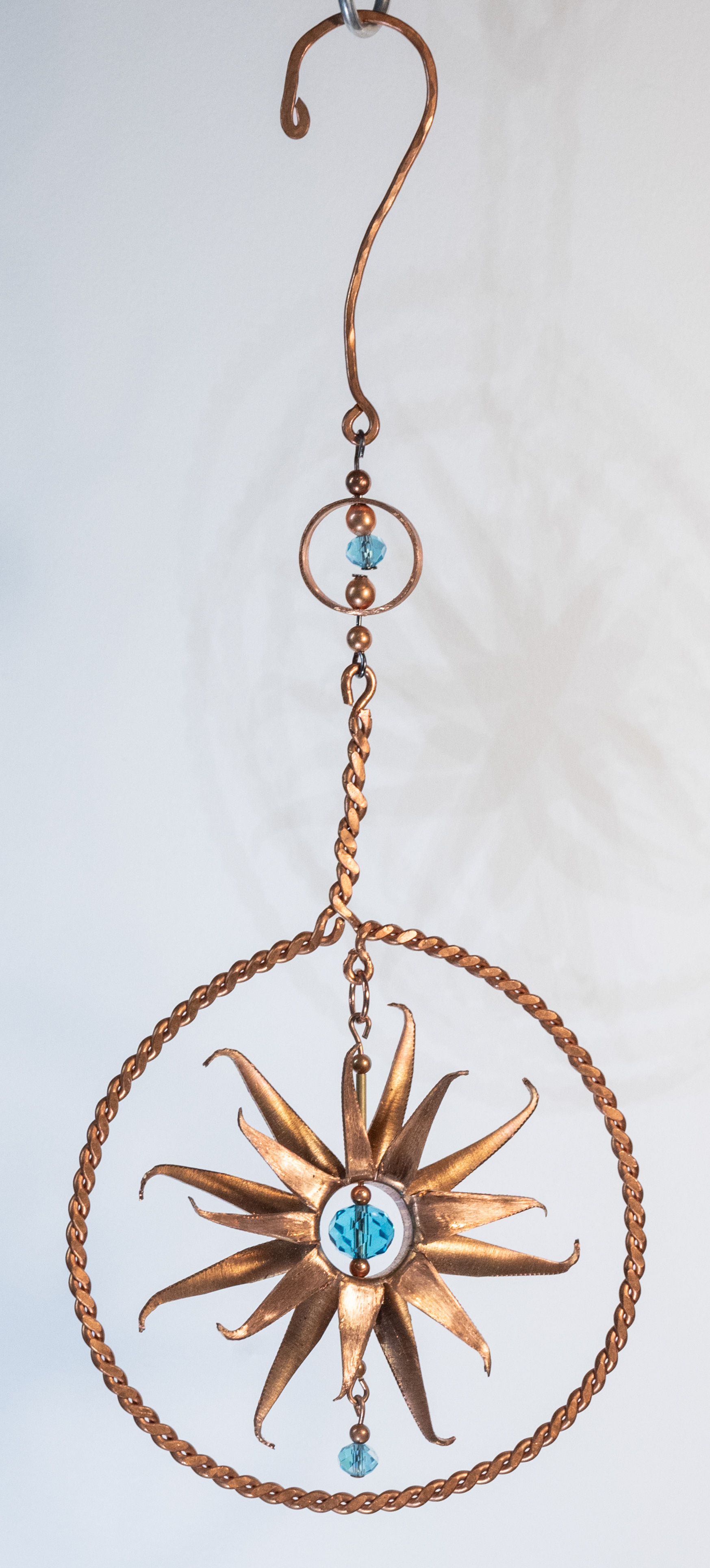 "Mirror mirror" is a hand twisted copper wire frame around a handcut copper flower and a turquoise glass centre, $75