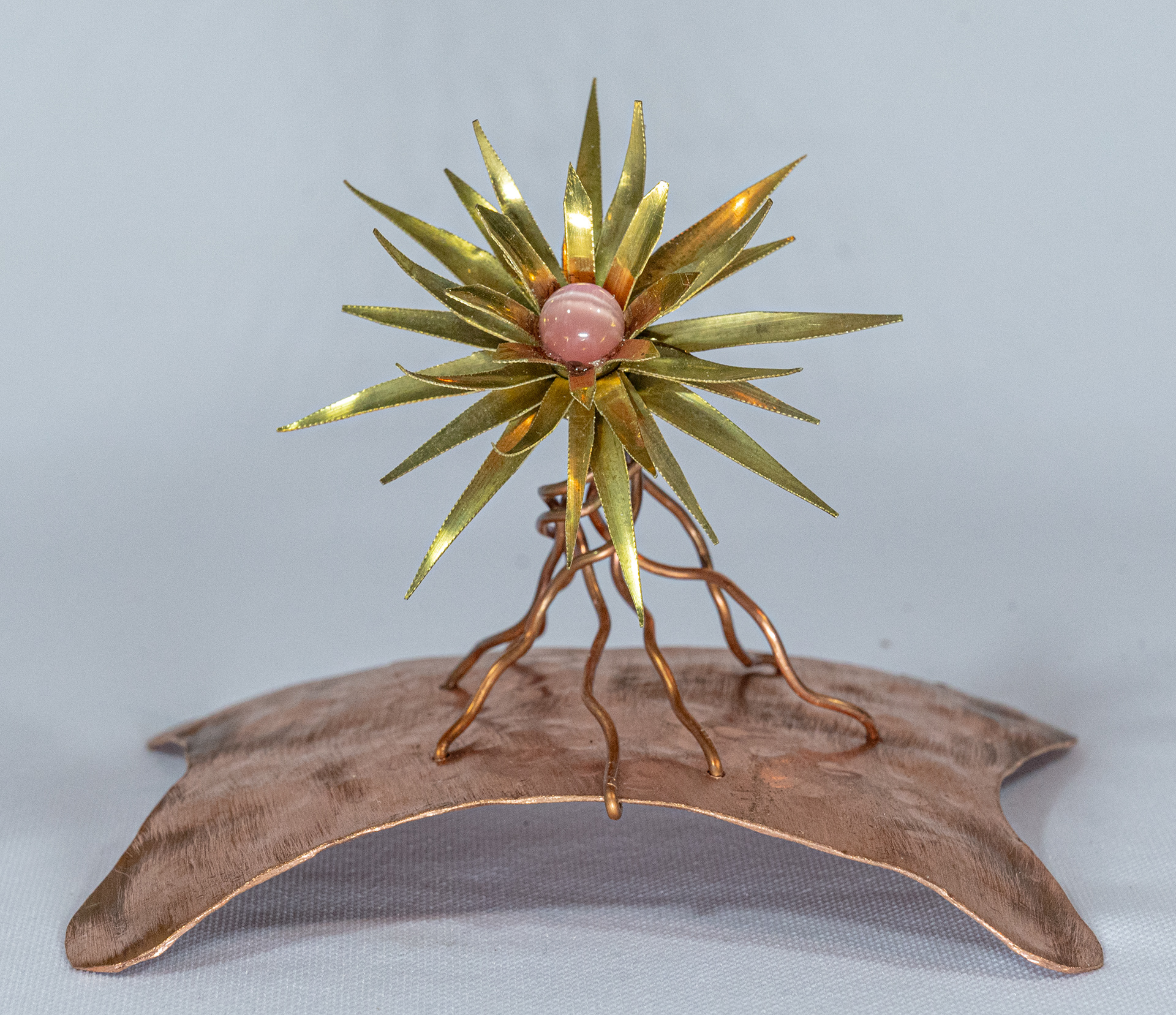 "Pink Tiger" is a brass flower with pink Tiger Eye bead on a hammered copper base, 4.5 inches wide x 3.5 inches deep x 3.5 inches high, $55