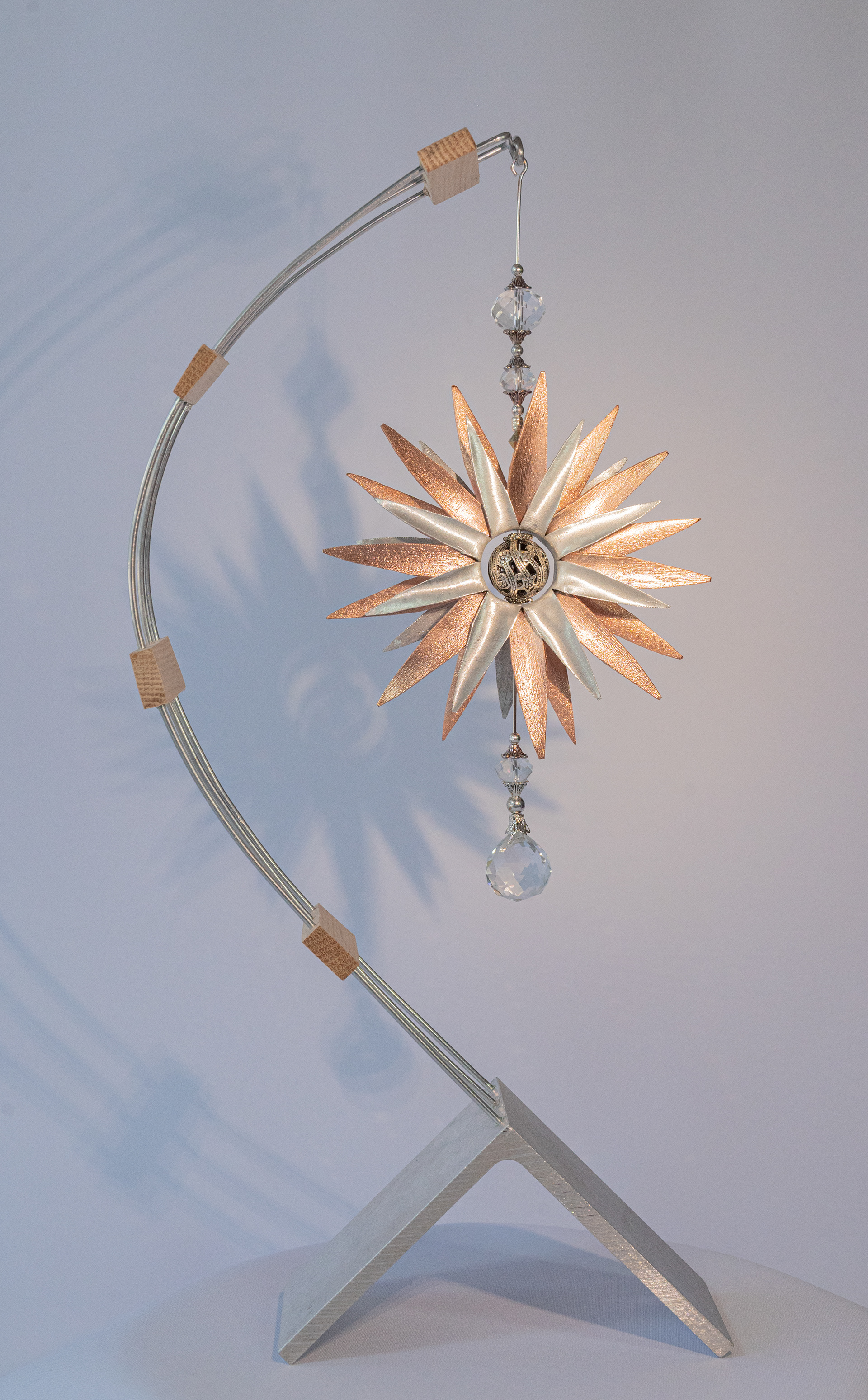 "Rhythmic Star" features a stunning copper and aluminum flower with metallic beads and clear crystal accents. The curved aluminum wires have cedar frets attached to an aluminum base, 15 inches high x 6 inches wide x 2.5 inches deep, $175