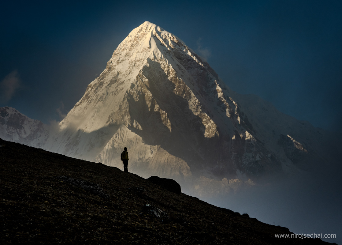 A trekker in the hiking around Everest region during sunset