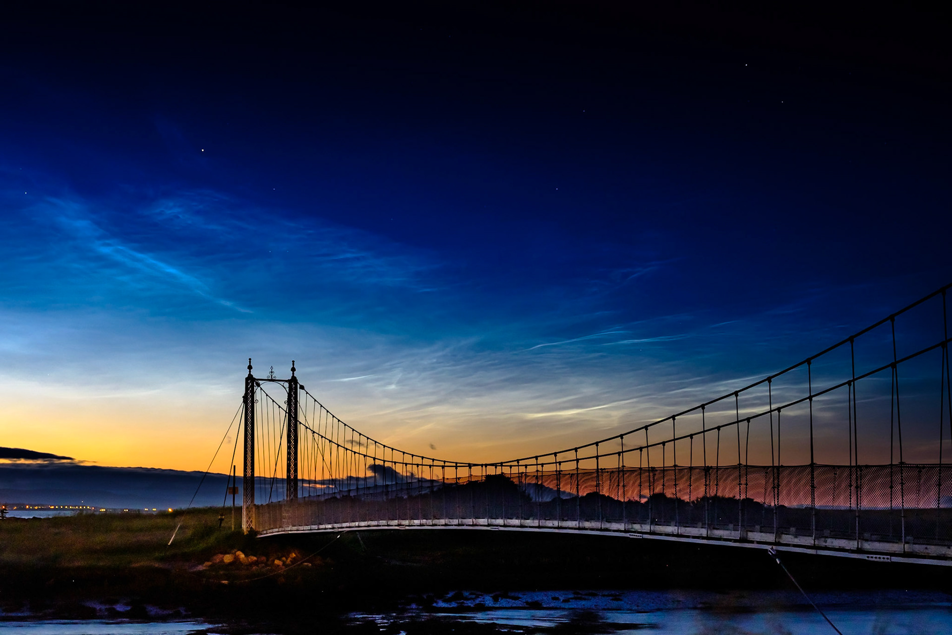 The eerie blue light of noctilucent clouds above Tain's Alexandra Bridge.