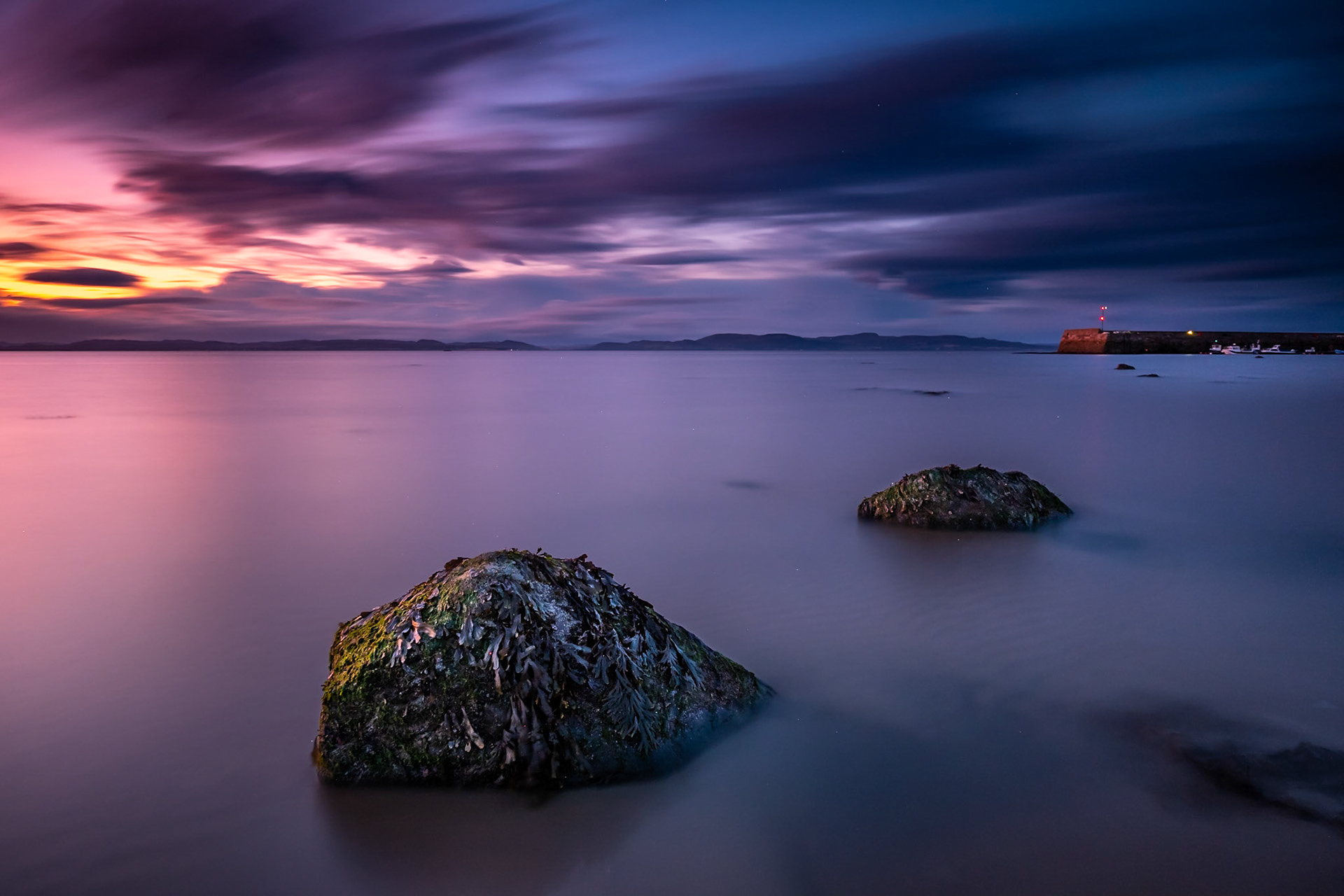 Fading light catches a rock in a calm sea at Portmahomack