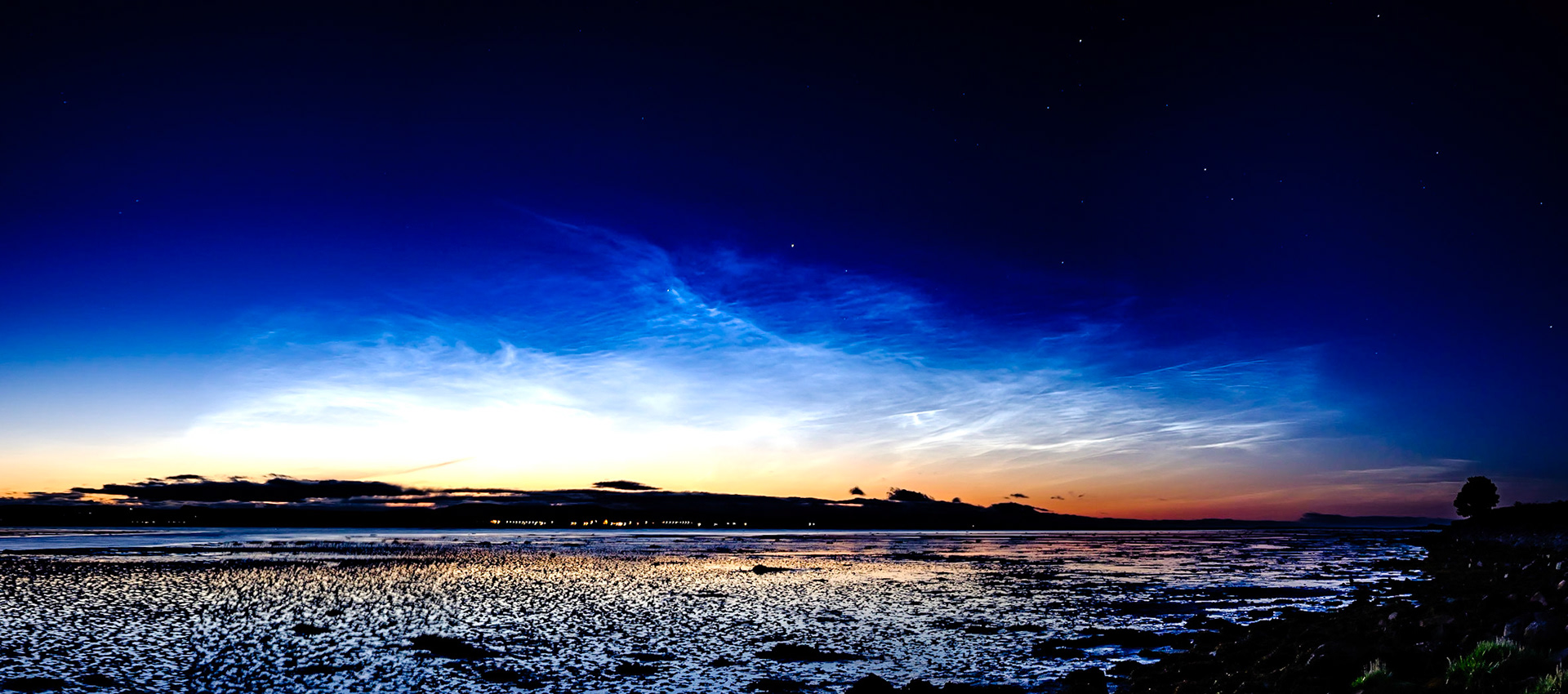 The Dornoch Firth picks up the reflected colour of upper atmosphere noctilucent clouds.