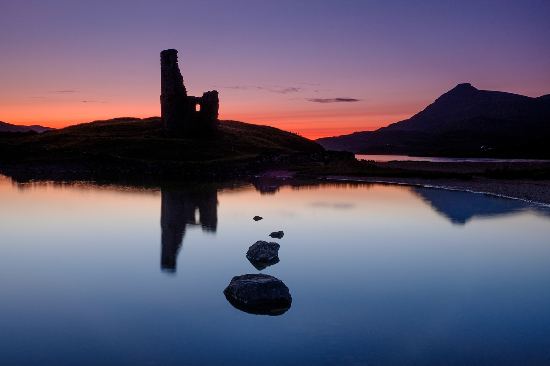 Ardvreck Castle on Loch Assynt provides a dramatic silhouette against the fading light.
