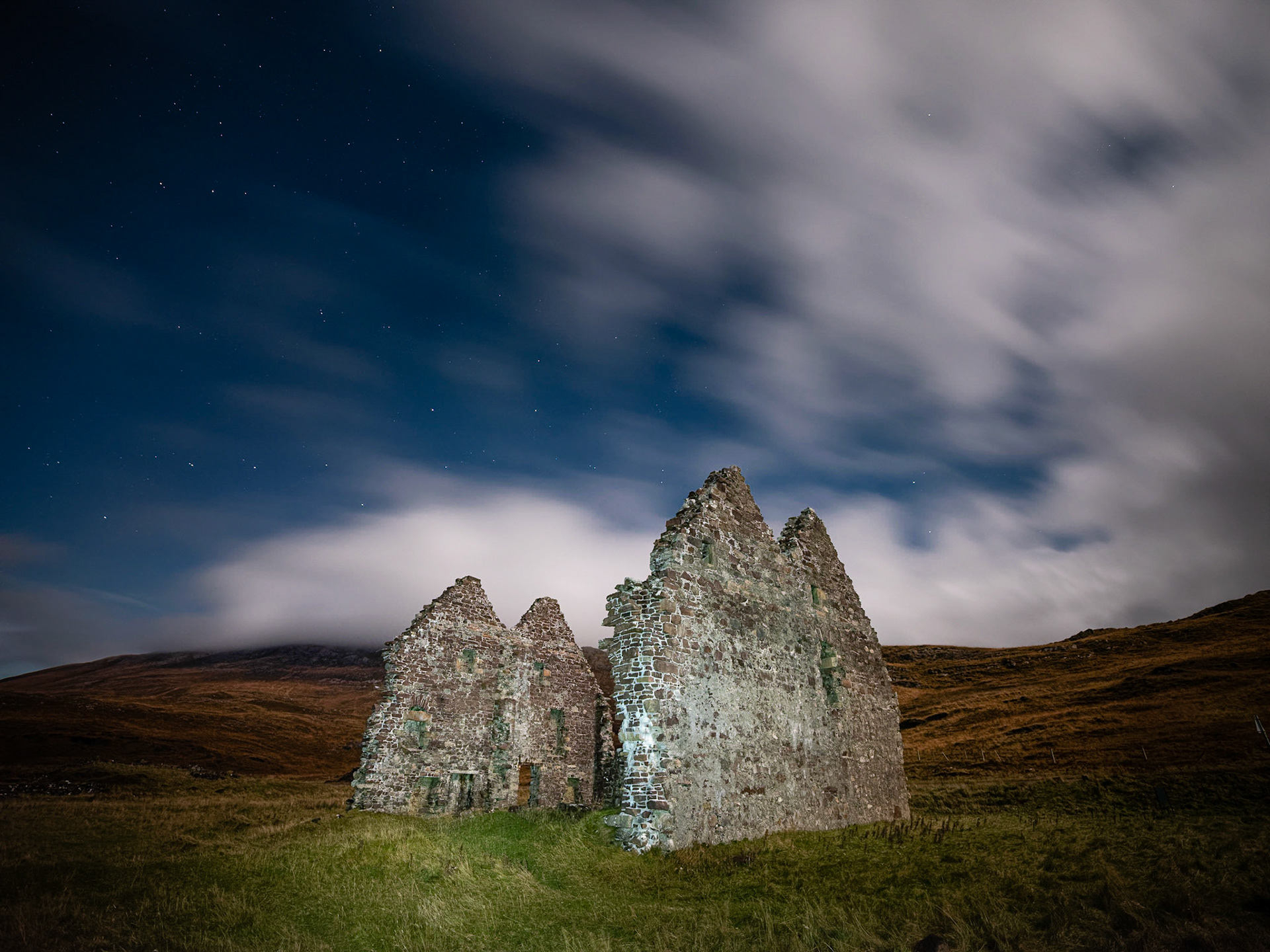 The start ruins of Calda House, set against fast-moving clouds.