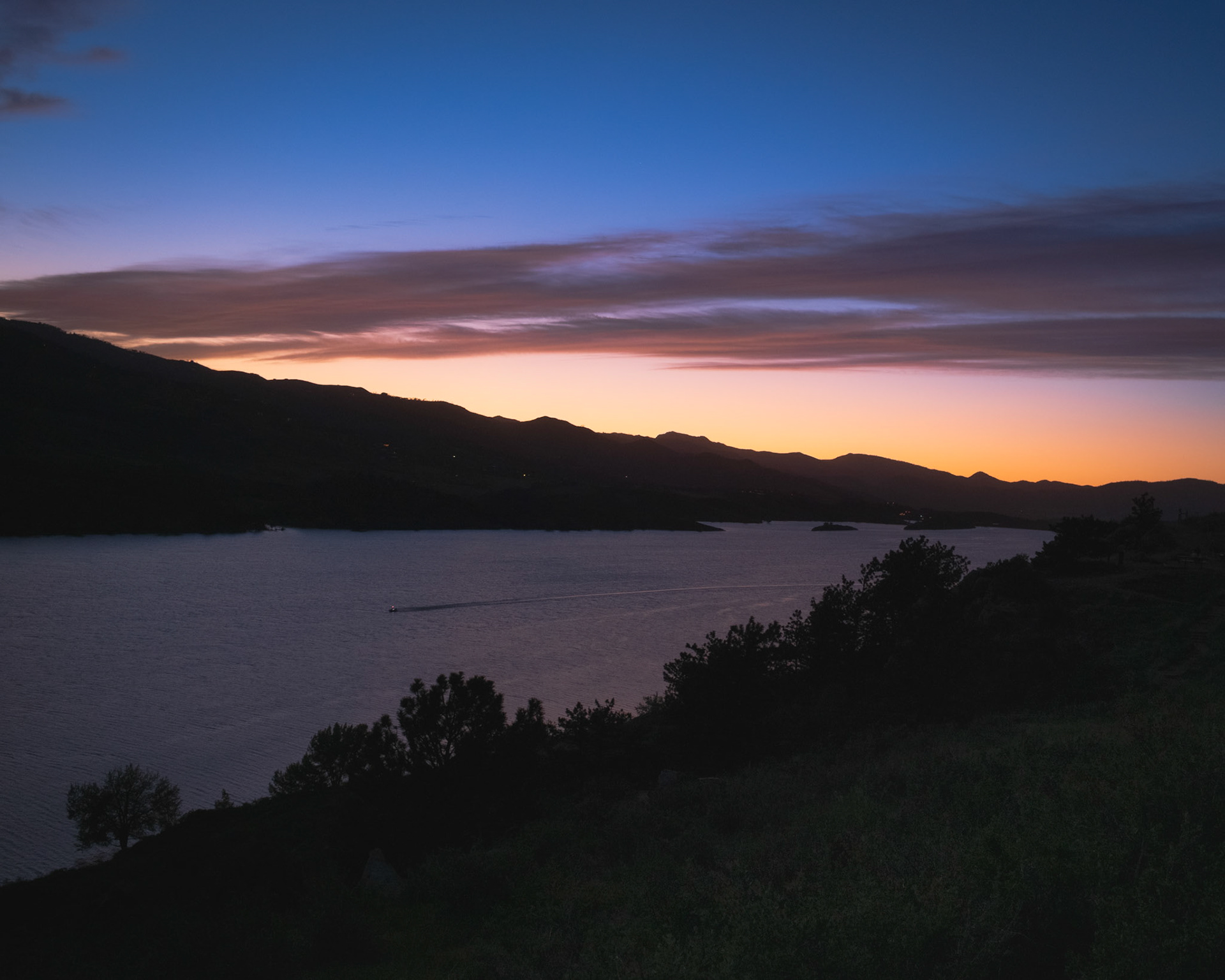 Blue hour looking northwest. I like the sky, but the foreground has nothing going for it. Boat wake is a nice, human element. Exposed for the sky and let the foreground go dark. Would have liked something more prominent closer to the lens.