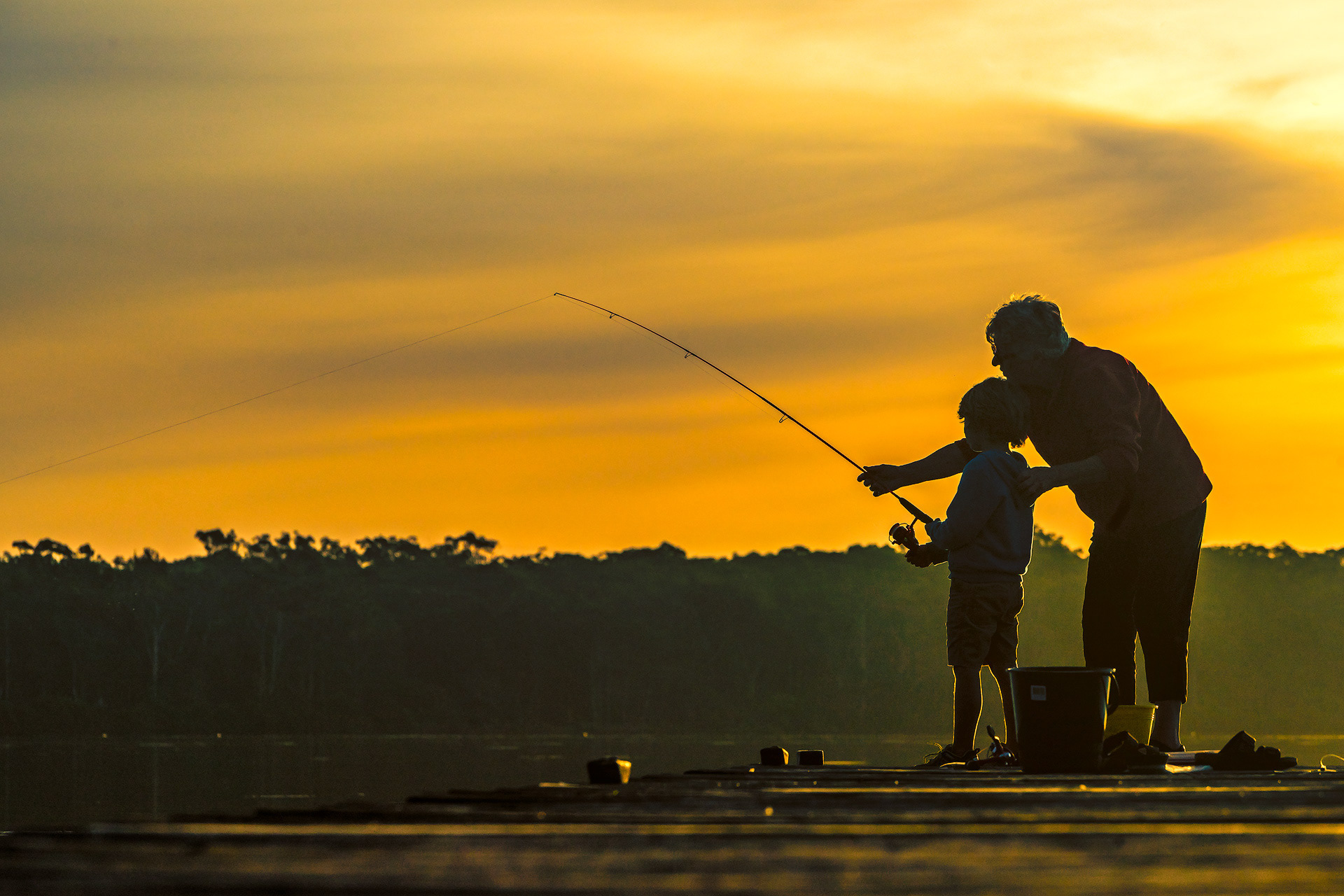 Sandy Fourie and Lyon Fourie fishing off jetty in Chain Valley Bay, NSW.
