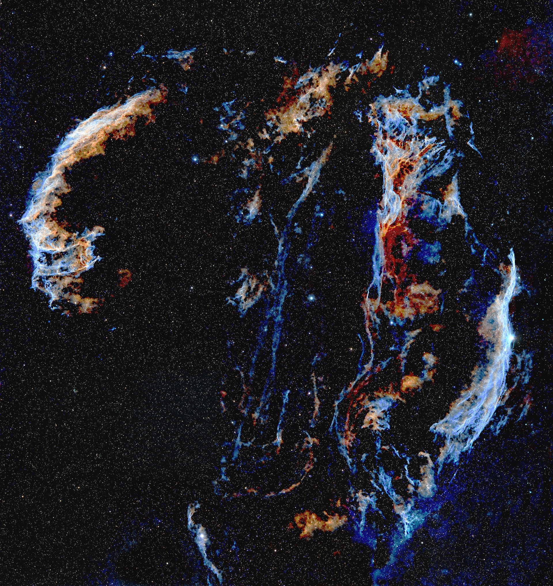 The Veil Nebula is a cloud of heated and ionized gas and dust in the constellation Cygnus. It was formed by the expanding gasses of massive star that exploded, a supernova, about 8,000 years ago. The entire nebula is 110 light-years across, covering six full moons on the sky as seen from Earth, and resides about 2,100 light-years away. The different colors are from energized gases, predominantly Hydrogen, Oxygen, and Sulfur, each with its own emission color. Given the size of this object, this image is a mosaic of two images combined to cover the entire nebula.