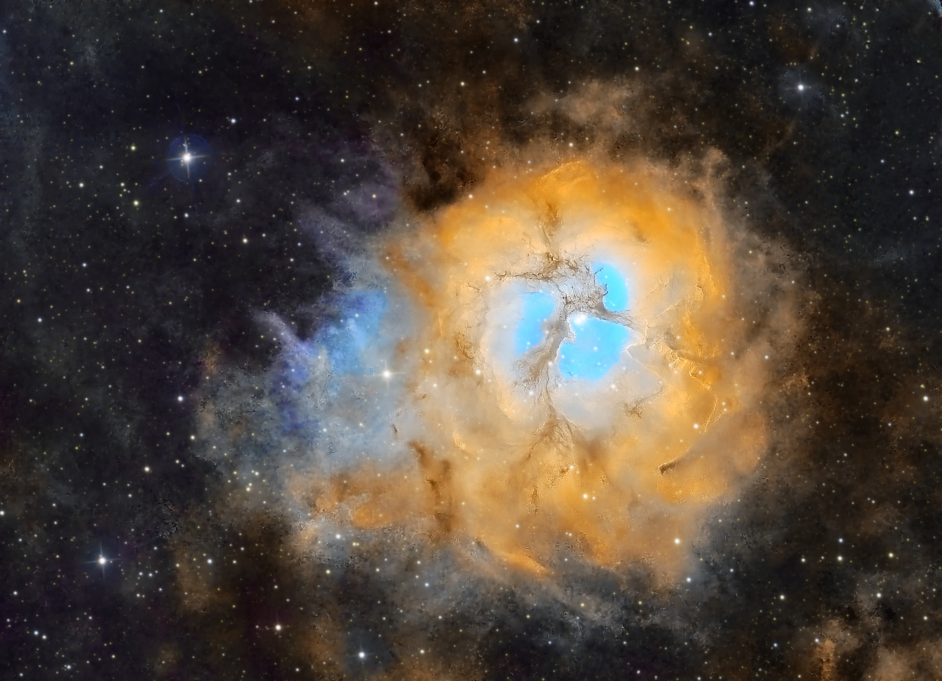 The Trifid Nebula (M20) in NB is a large star-forming region located in the constellation Sagittarius. The nebula’s name means “divided into three lobes,” and refers to the object consisting of three types of nebulae and an open star cluster. The open cluster is surrounded by an emission nebula, a reflection nebula, and a dark nebula within the emission nebula that gives M20 the trifurcated appearance for which it is known. It has a diameter of 42 light years and lies at a distance of 5,200 light years from Earth. SHO