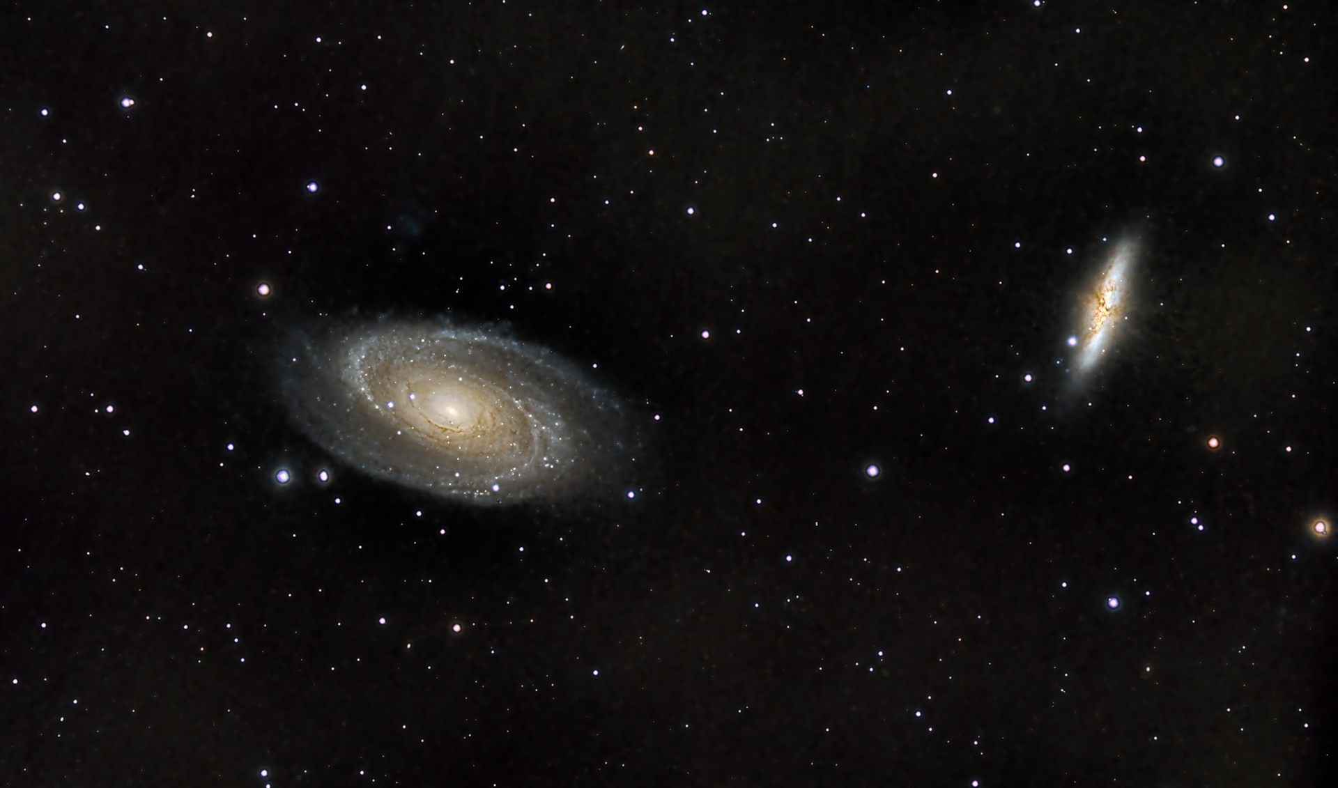 M81 and M82, a pair of galaxies about 11.5 million light years away from earth. The large spiral is often called Bode's Galaxy, and the smaller is known as the Cigar Galaxy. The dark bands in the cigar are Hydrogen bands where stars are forming. About 1000 images were used taken to make up this final photo!