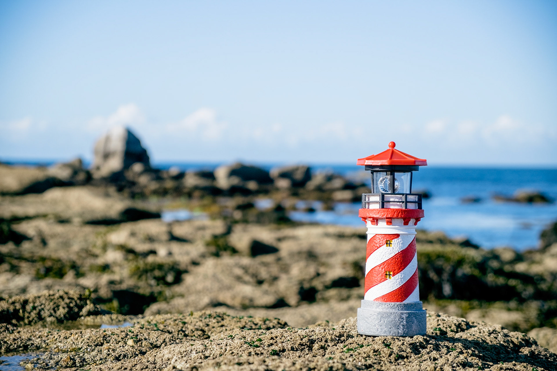 Toy lighthouse on granite rocks on the breton south coast