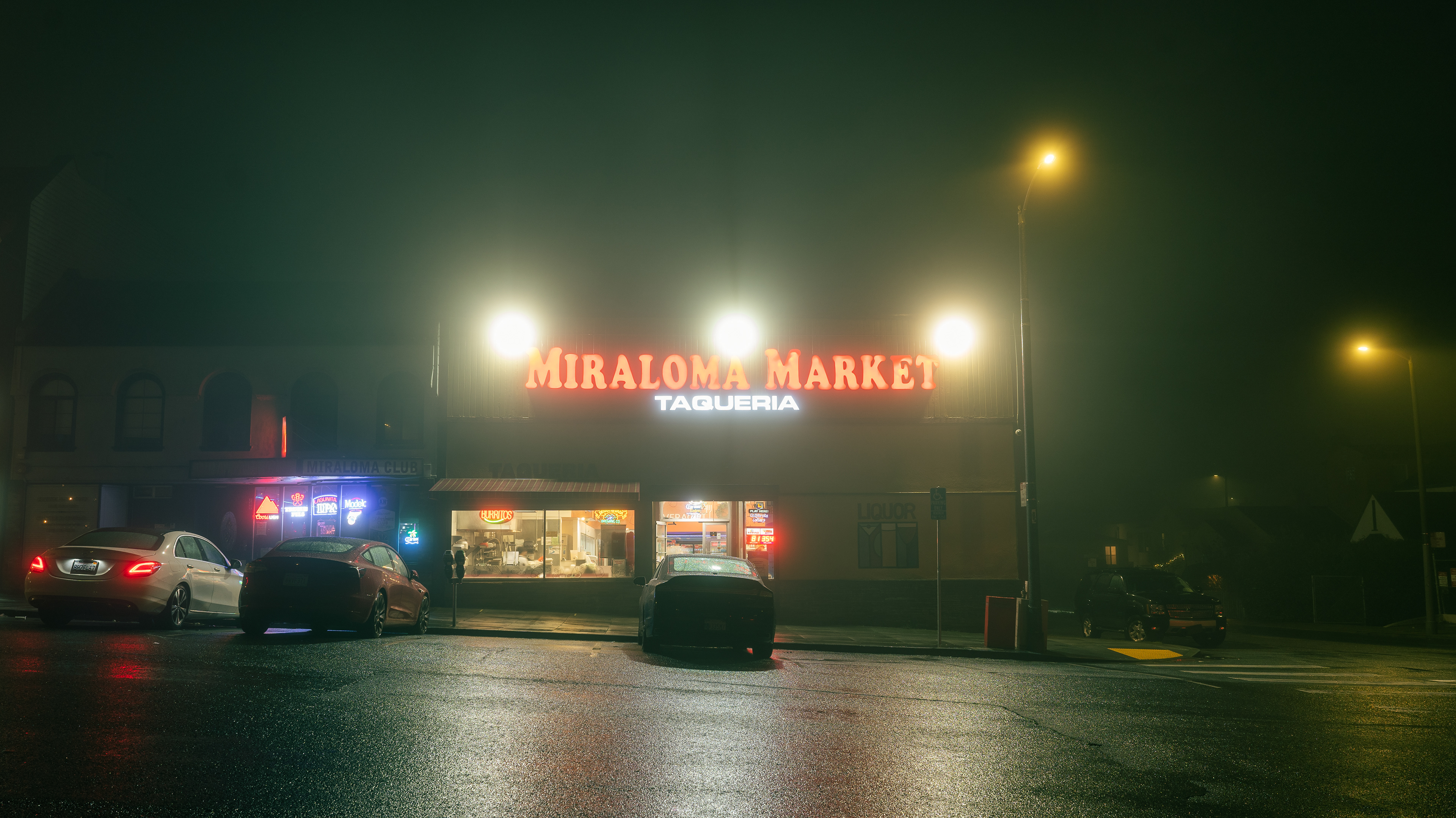 Hazy lights above Miraloma Market illuminate the streets off Portola Drive