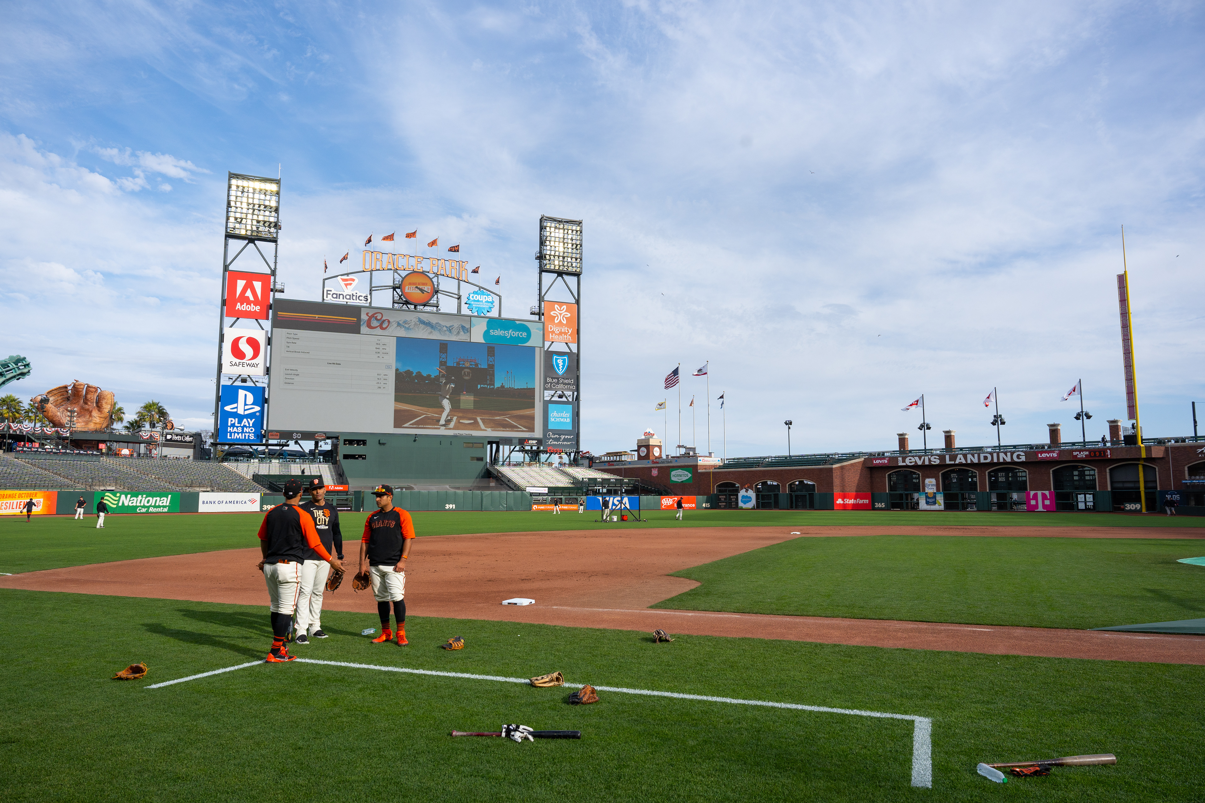 Players talk at third base during practice.