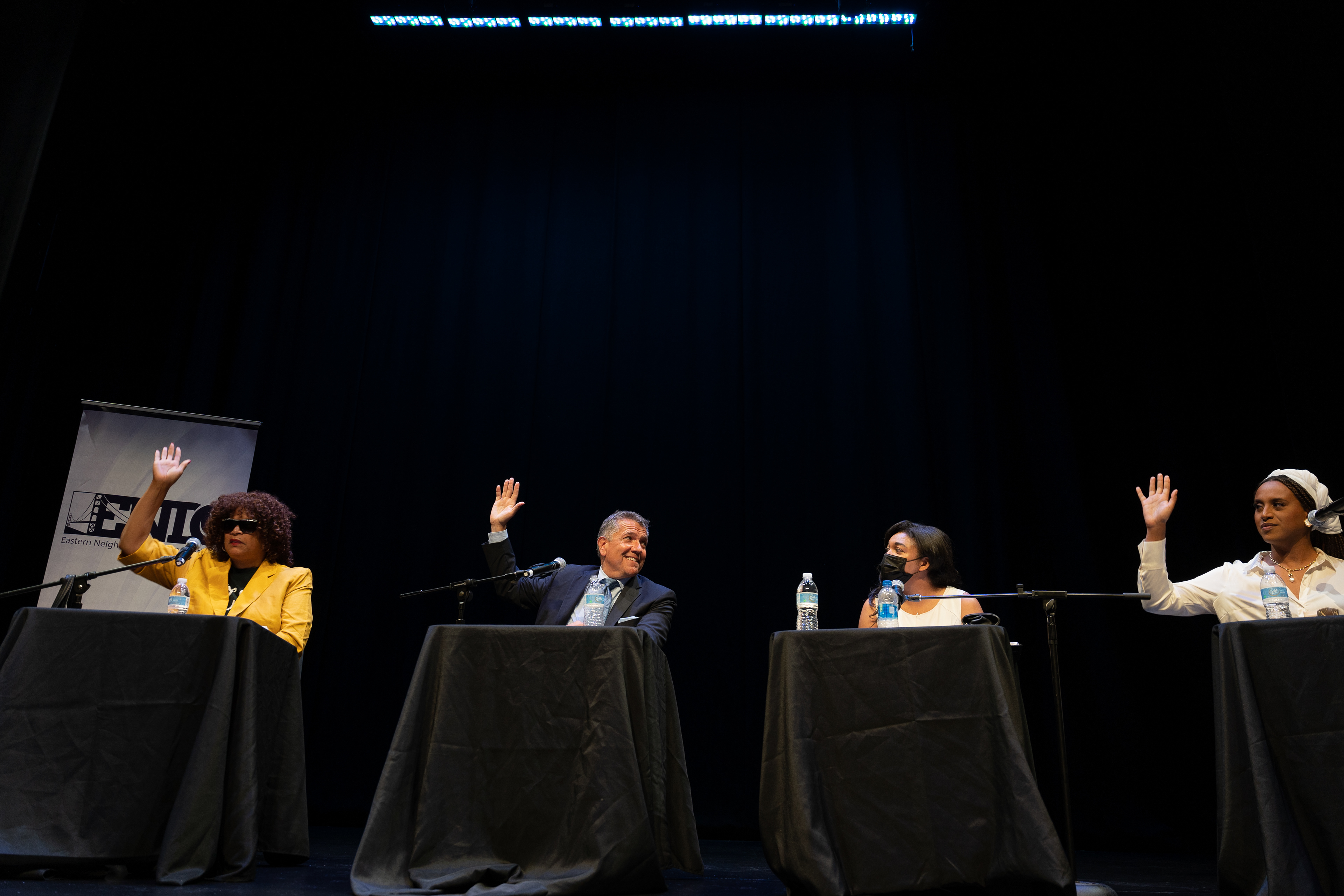Candidates show support for issues by raising their hands.