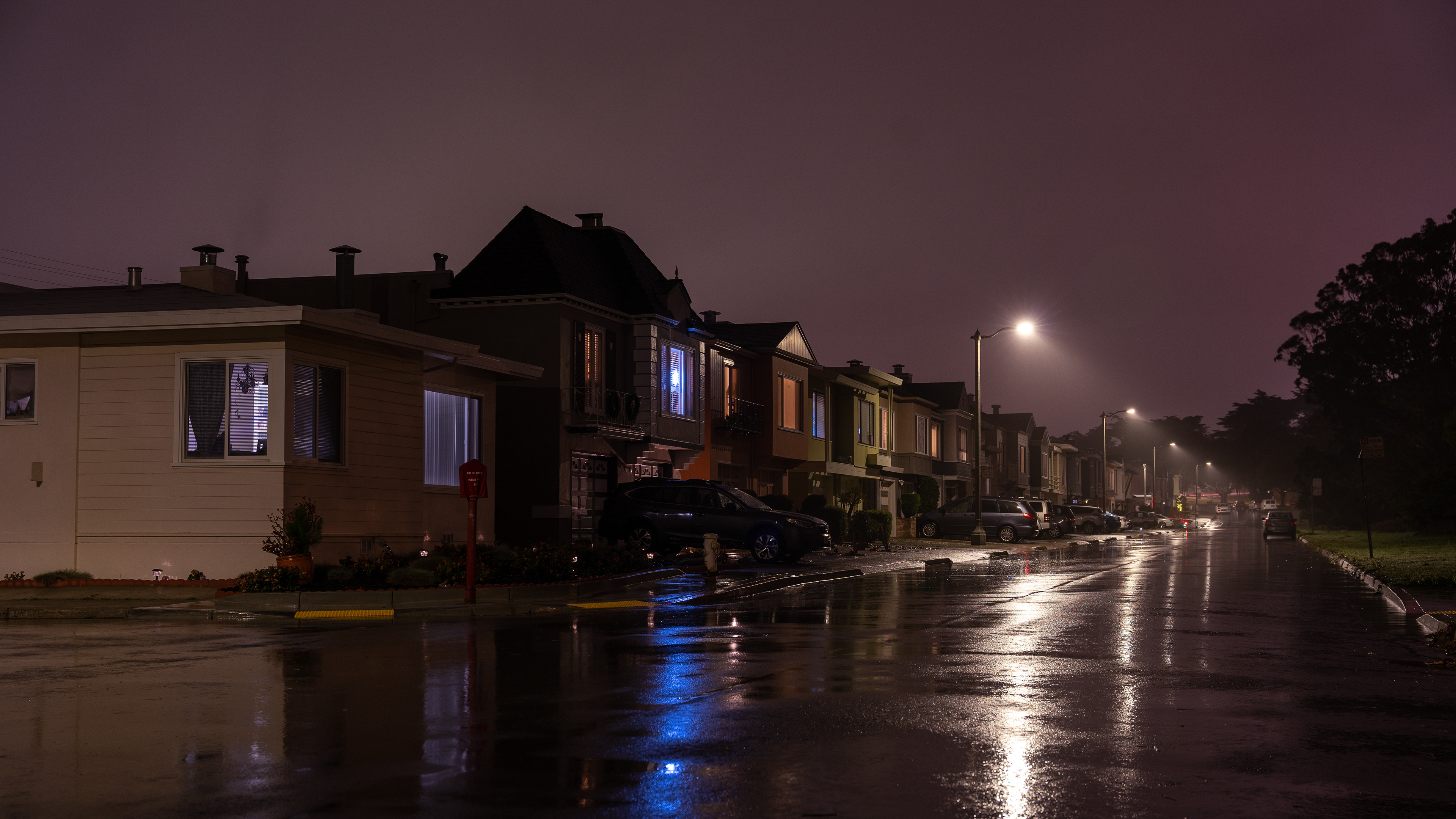 A row of streetlamps outside homes in the Outer Sunset fade off into the night