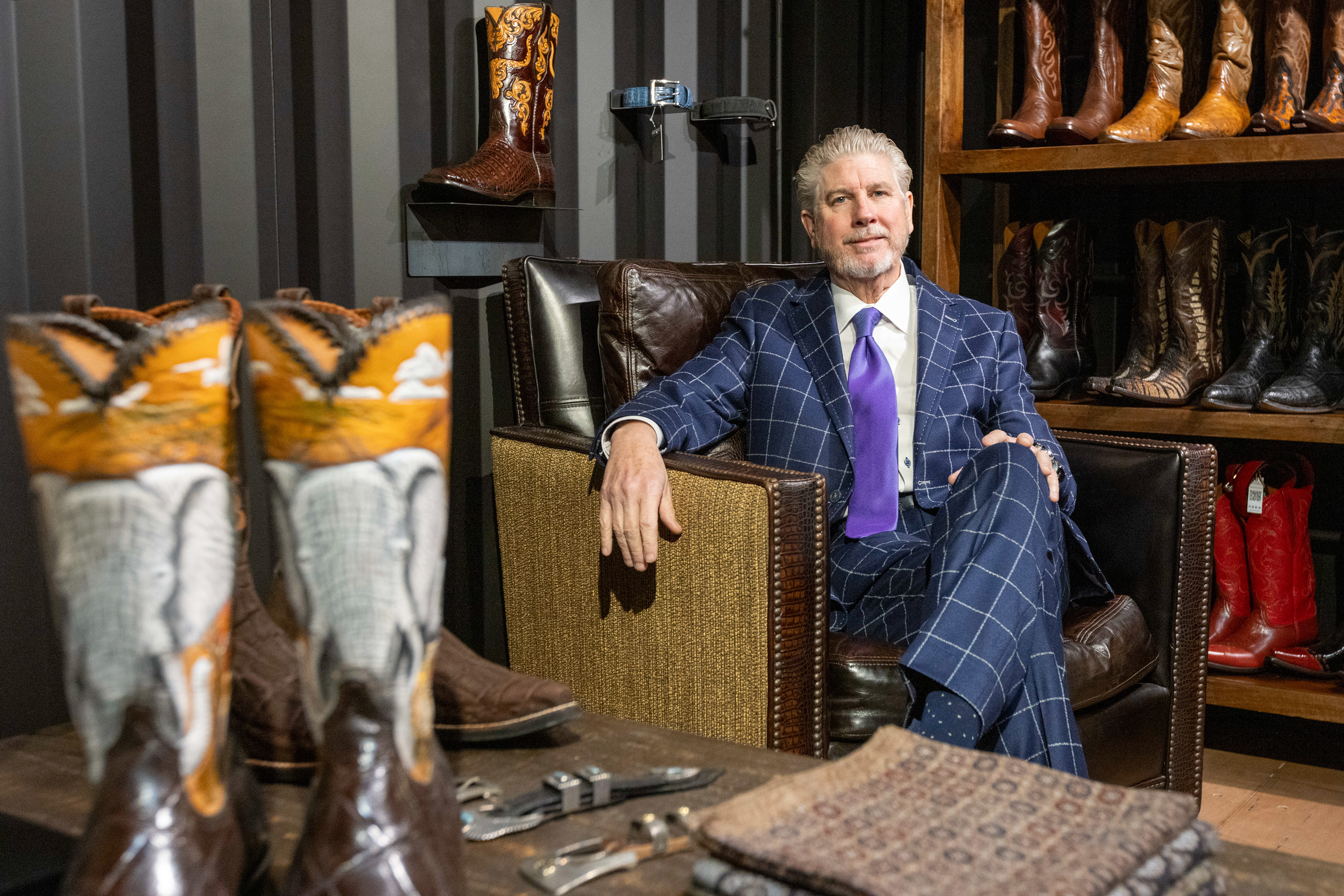 Founder and president Bob Baumann pictured with a selection of custom boots at Edward Baumann Clothiers, Monday, Feb. 10, 2025, in Addison.